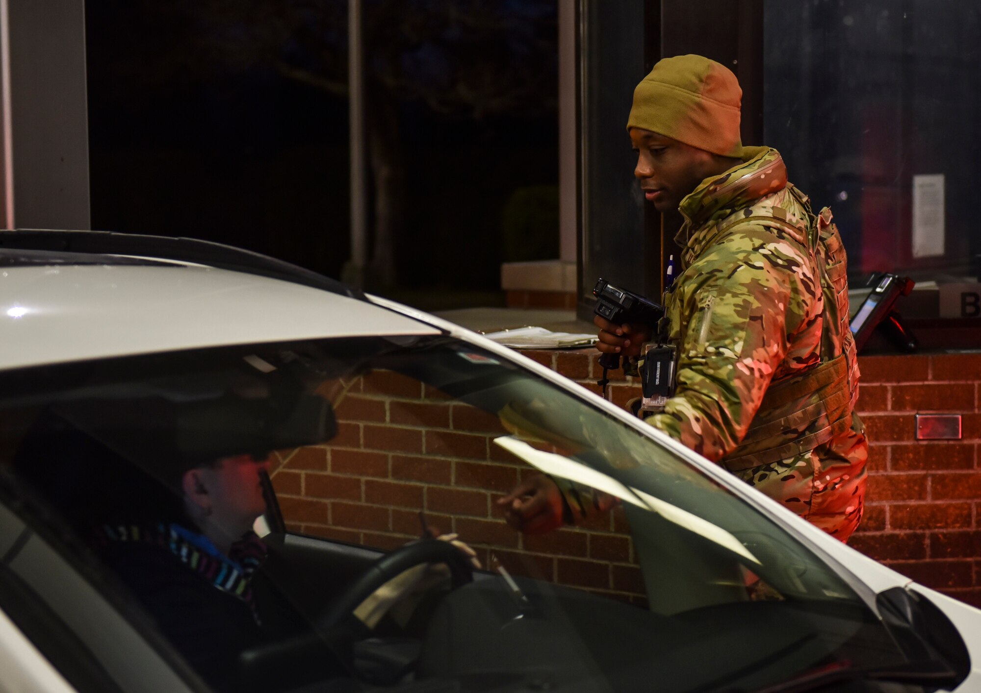 U.S. Air Force Senior Airman Joseph Stevens, 92nd Security Forces Squadron security forces journeyman, checks ID cards at the front gate of Fairchild Air Force Base, Washington, Feb. 27, 2020.