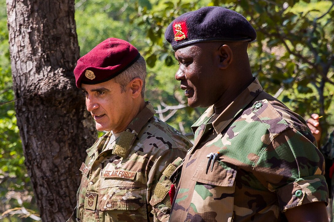 Two men in uniforms walk side-by-side.