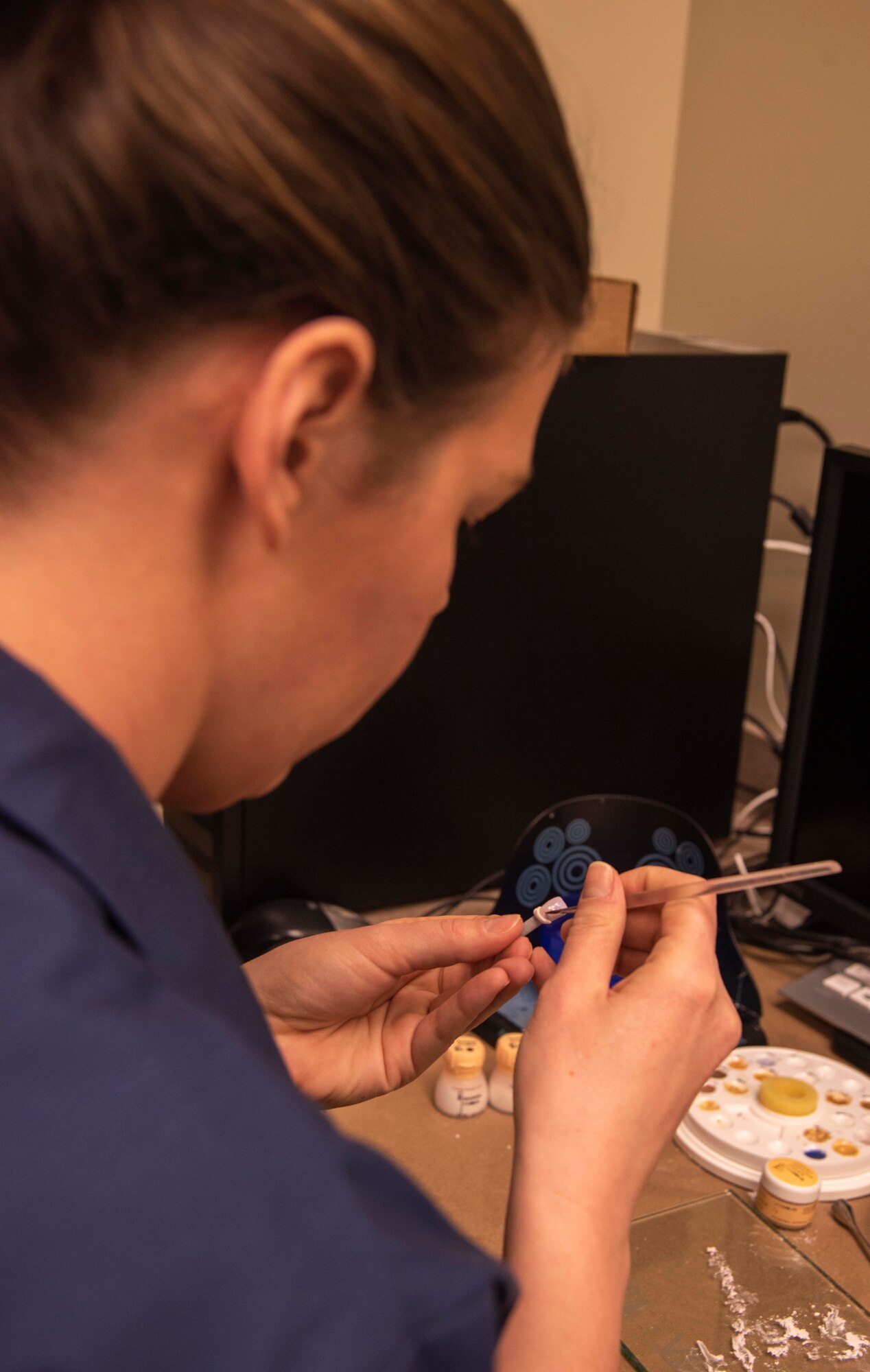 U.S. Air Force Staff Sgt. Brittaney Wigginton, 92nd Aerospace Medicine Squadron NCO in charge of dental support, paints a tooth cap for a patient Feb. 27, 2020, at Fairchild Air Force Base, Washington.