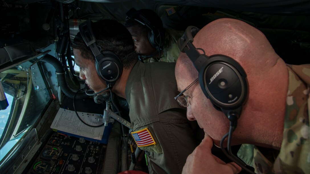 U.S. Air Force Chief Master Sgt. Daniel Simpson, the 18th Air Force command chief, views Airman 1st Class Malachi Greman, a 50th Air Refueling Squadron boom operator, refueling a KC-46 Pegasus aircraft from McConnell Air Force Base, Kan., aboard a KC-135 Stratotanker aircraft, Jan. 30, 2020.