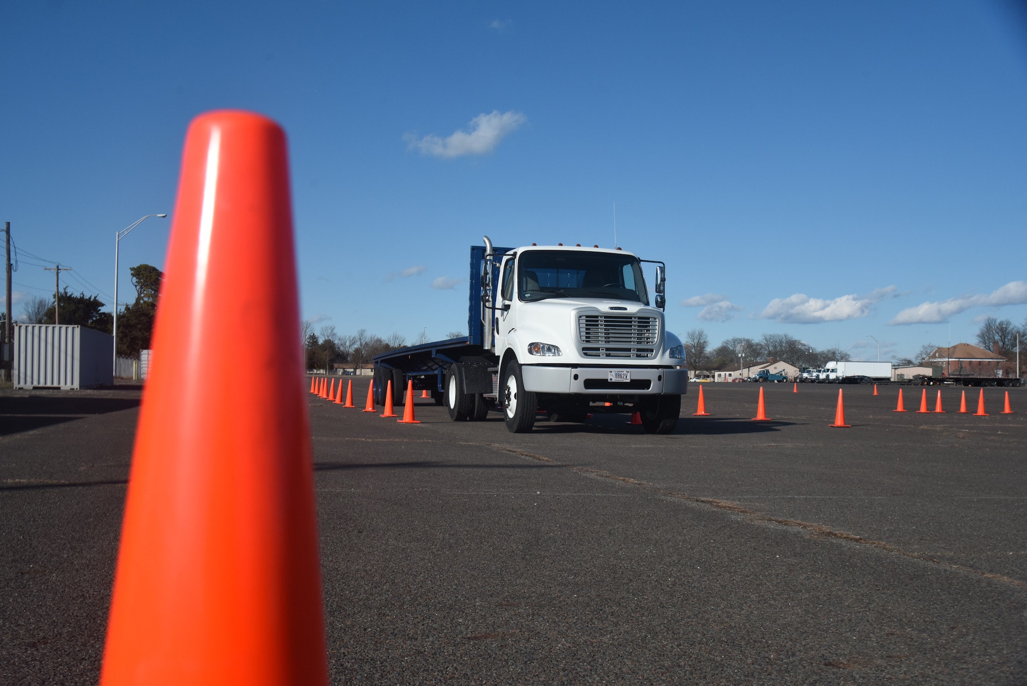A vehicle waits between cones in a parking lot.