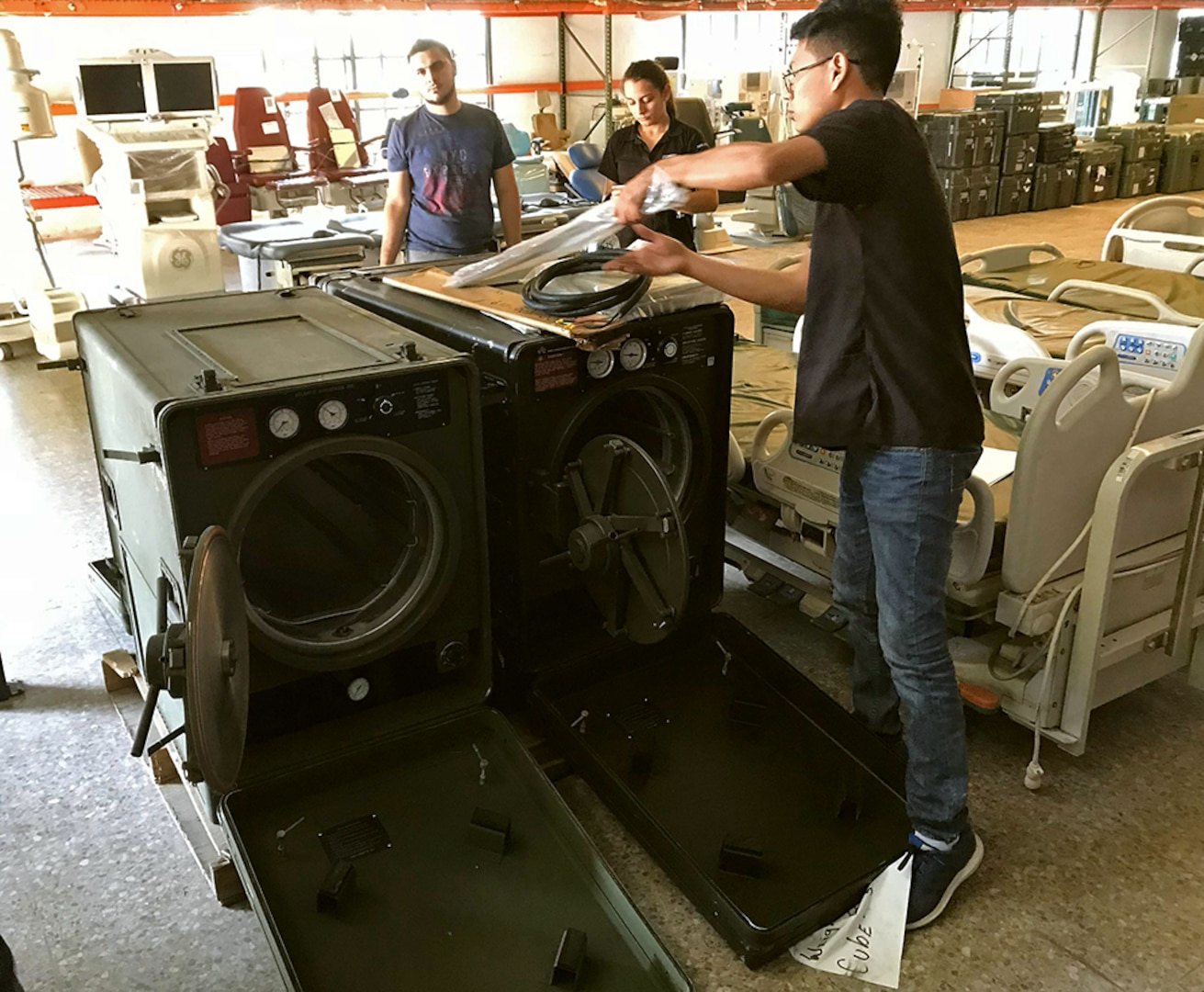 Hospital workers prepare a machine for use.