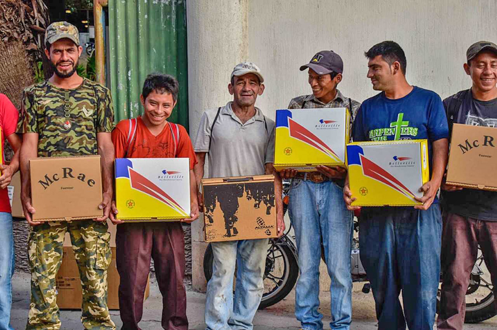 Farmers show boxes of their new boots.