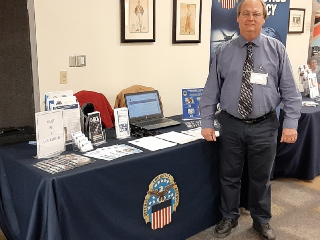 Jay Hilderbran stands ready to greet potential candidates to the DLA Land and Maritime Booth at the College of Arts and Sciences Economics Department Spring Career on February 20, 2020.