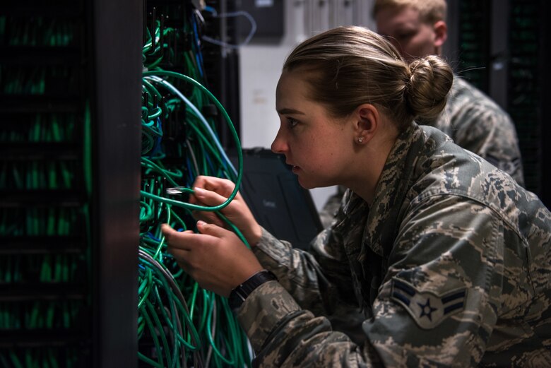 A U.S. Air Force Airman patches a computer to a network.