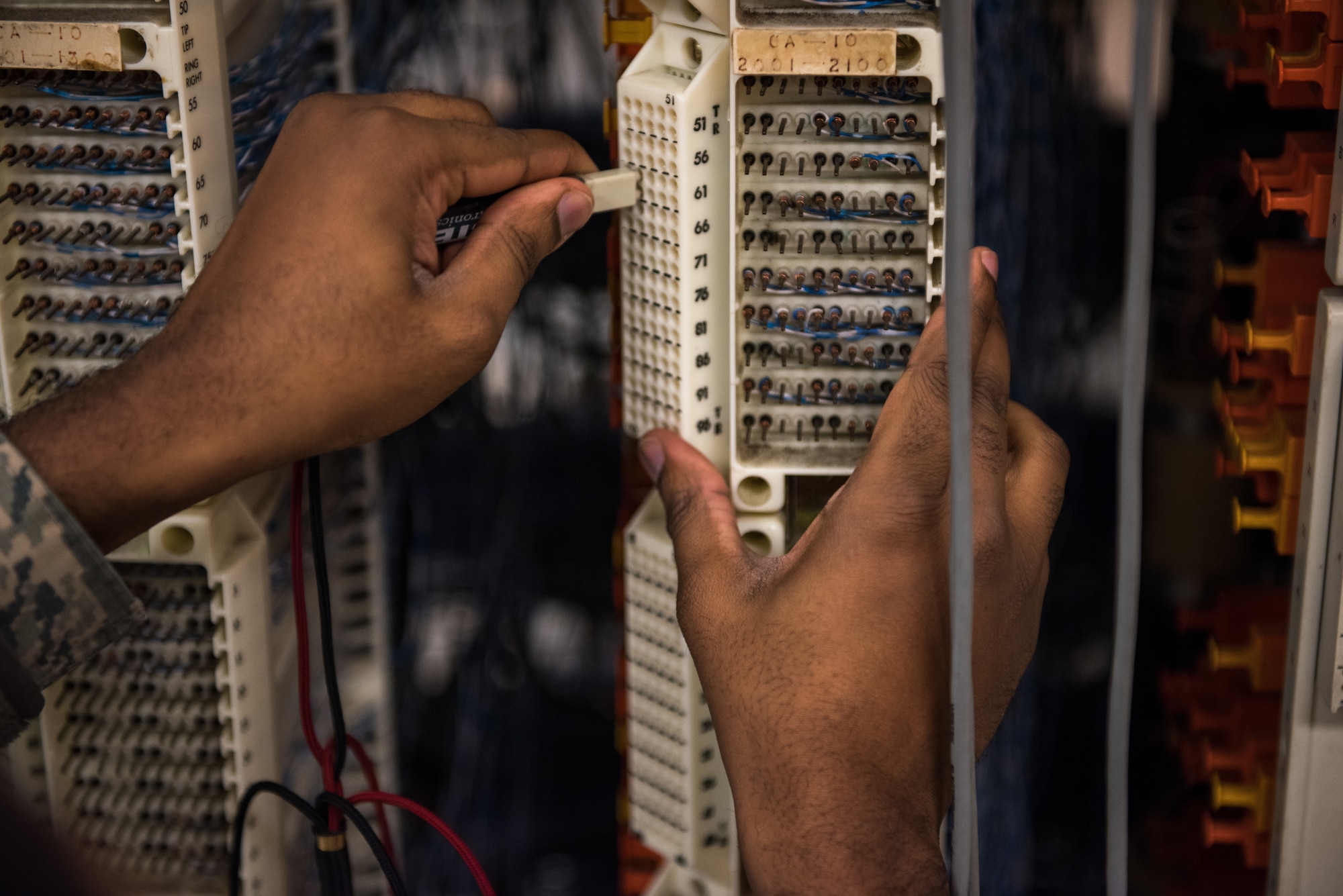 A U.S. Air Force Airman verifies phone numbers on landlines.