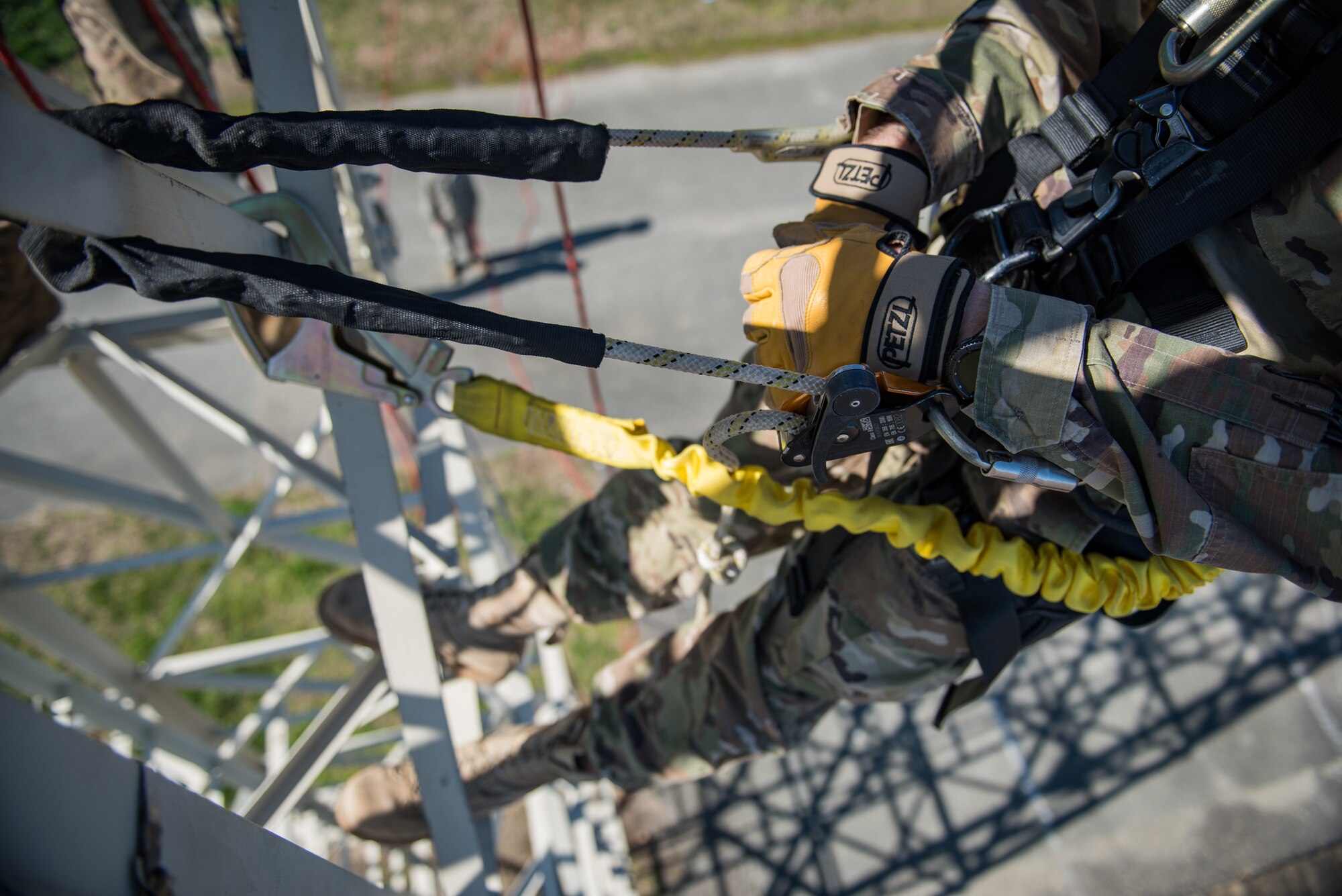 A U.S. Air Force Airman hangs from a training tower.