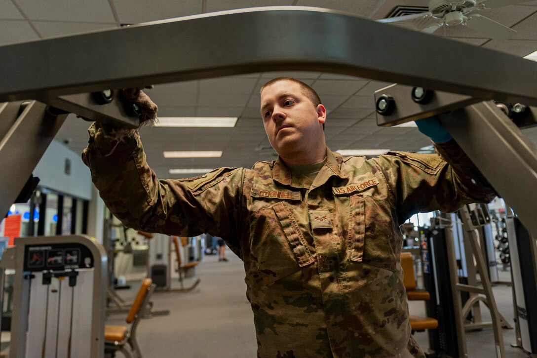 Photo of Airman cleaning fitness equipment