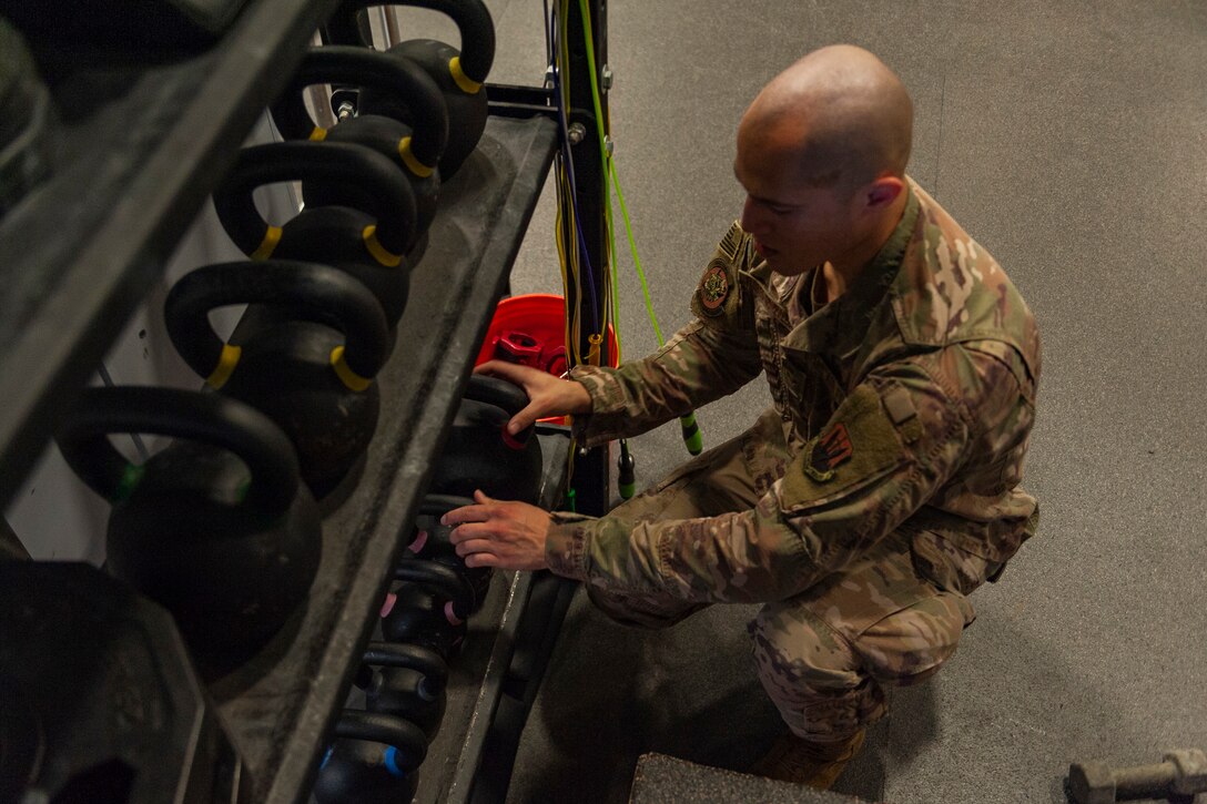 Photo of Airman organizing kettlebells