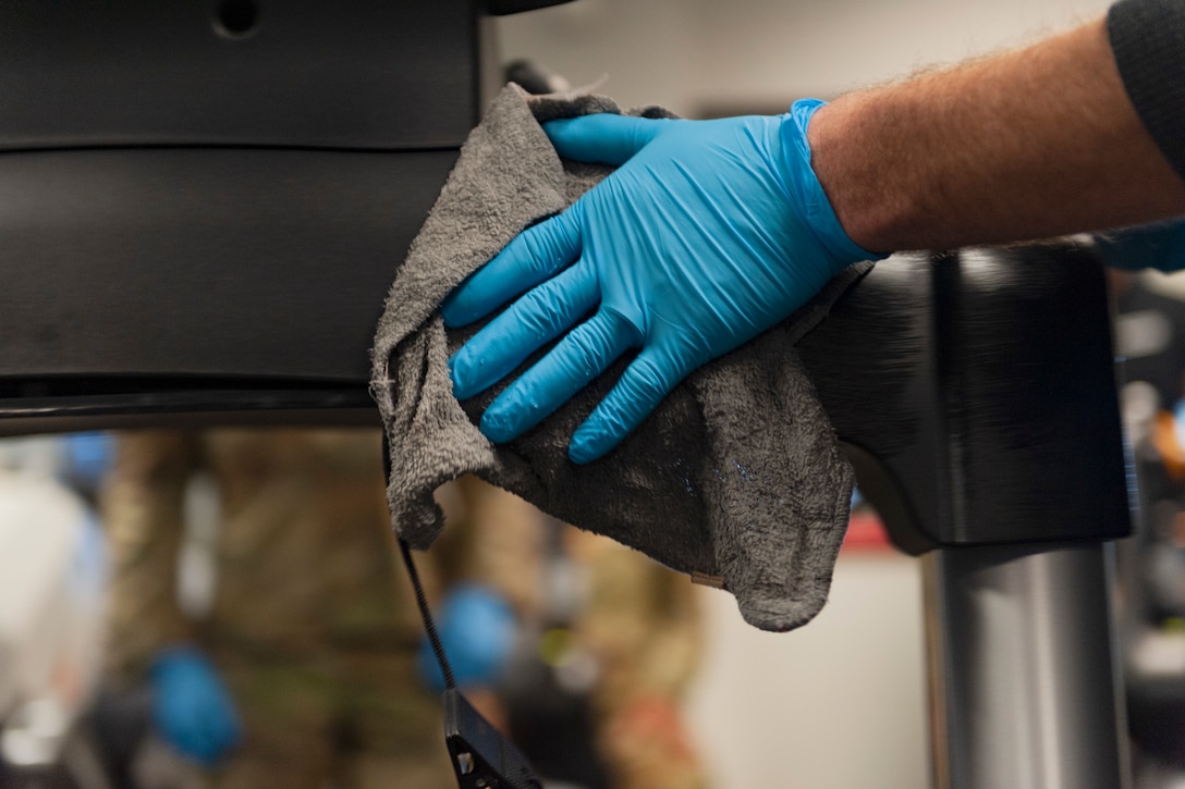 Photo of Airman cleaning fitness equipment