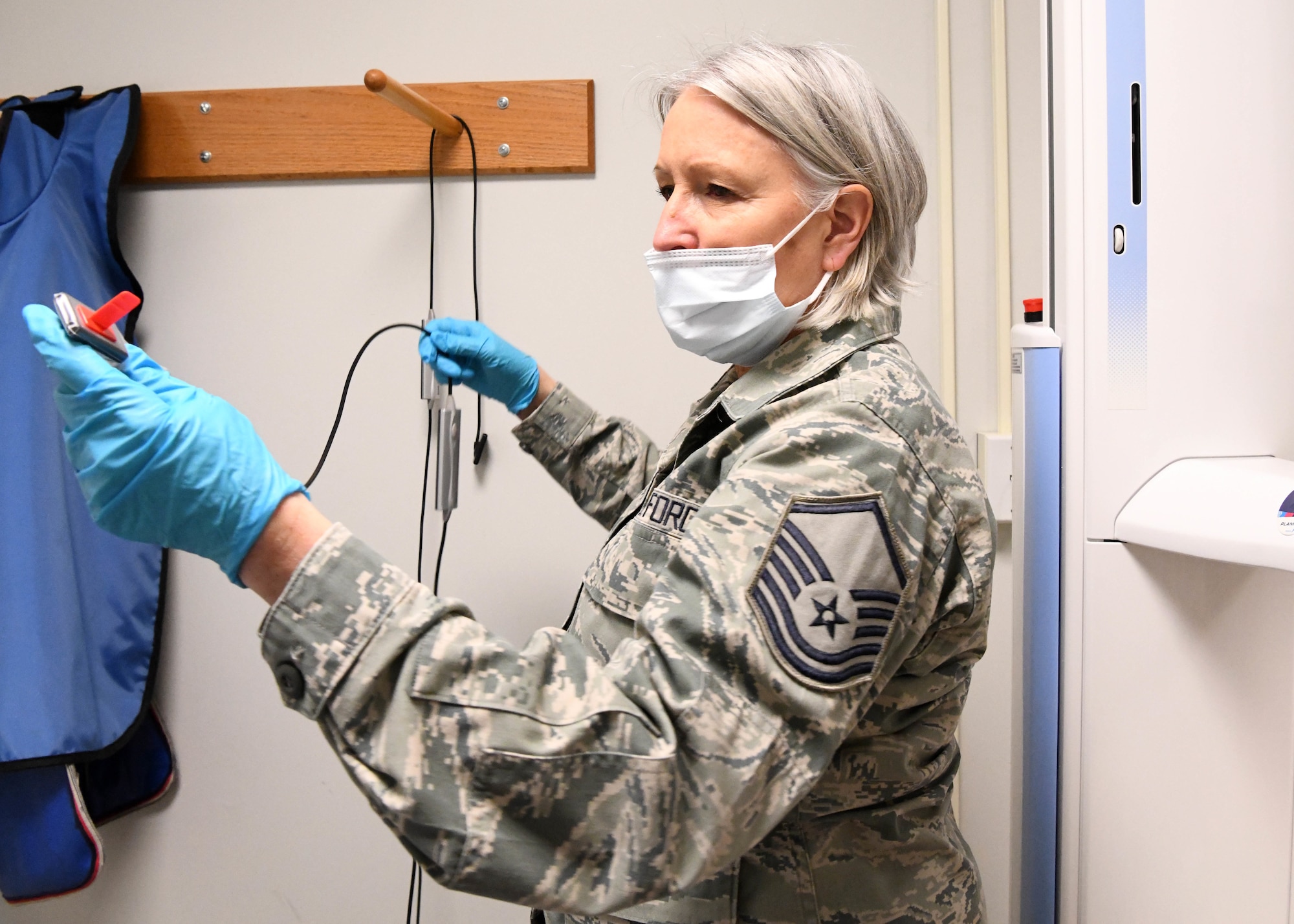 Master Sgt. Terrylee Crowther, 104th FW Dental Assistant puts on protective equipment for a dental examination. As the NCOIC of Dental at the 104th Fighter Wing, she ensures members are up to date on dental screenings so they can stay deployment ready. (U.S. Air National Guard Photo by Airman Camille Lienau)