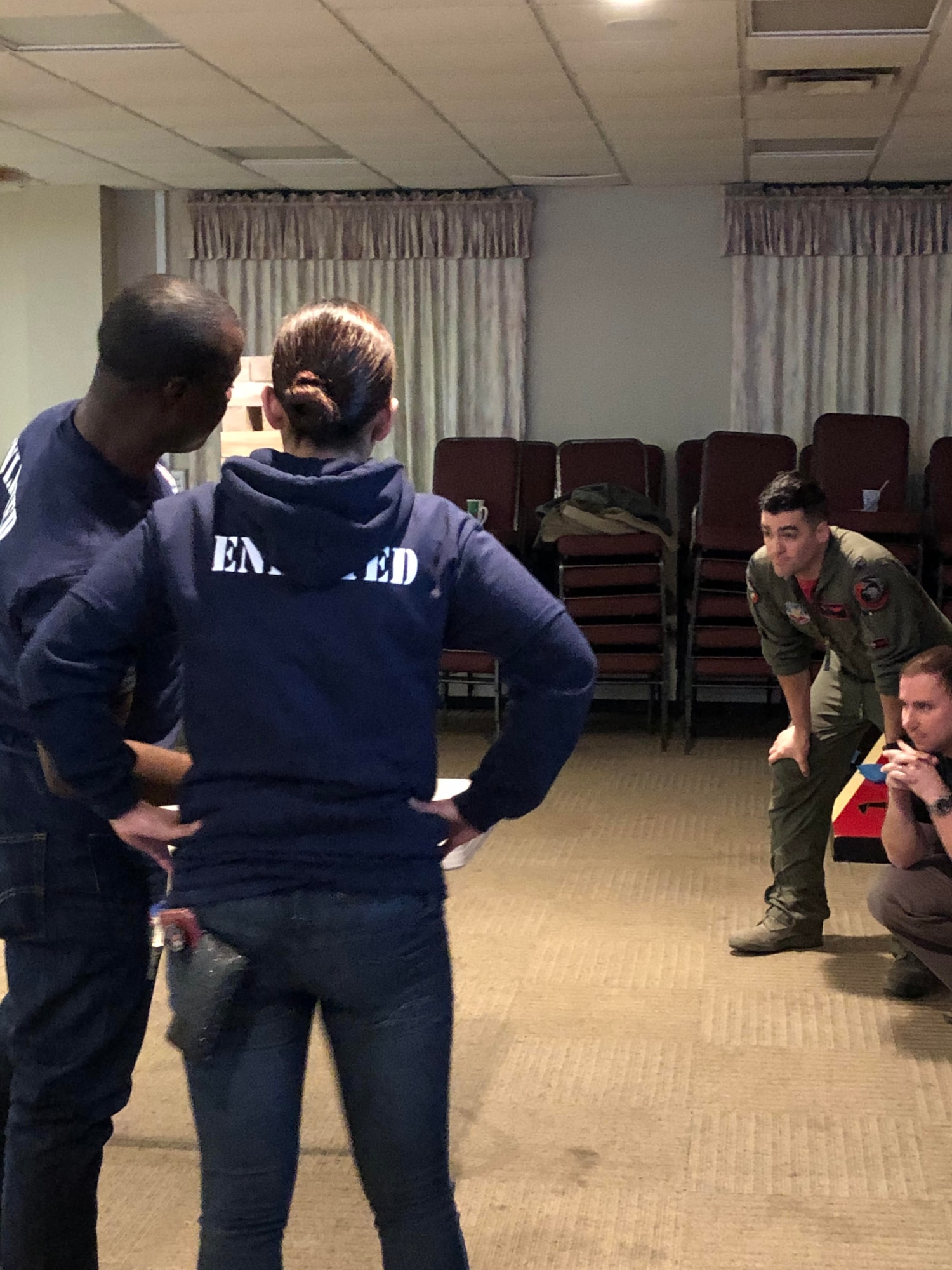 Staff Sgt. Shemron Ross and Airman 1st Class Mabell Teixeira (Left to Right) of the 104th Force Support Squadron look at their options for removing a game piece from the Jenga tower with intense concentration during the last competition against the officers. At the same time, the officers strategize their next move during the 104th Fighter Wing’s 2nd annual Officer vs. Enlisted Olympic games, Feb. 1, 2020. The enlisted and the officers took part in a friendly competition as part of the Wing’s camaraderie with the final score of enlisted 14 officers 13. (U.S. Air National Guard photo by Senior Master Sgt. Julie Avey)