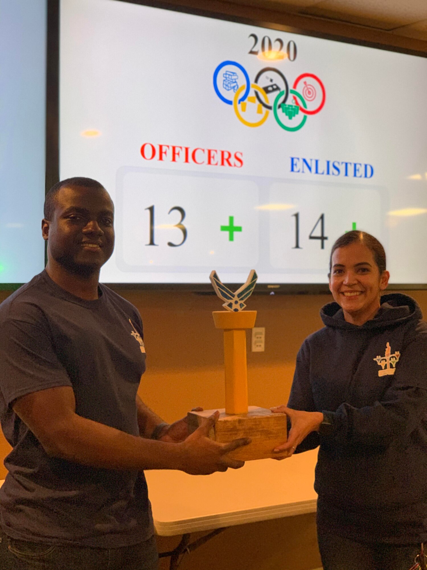 Airman 1st Class Mabell Teixeira and Staff Sgt. Shemron Ross of the 104th Force Support Squadron, celebrate after they won the 104th Fighter Wing’s Officer vs. Enlisted Olympics, Feb. 1, 2020. Teixeira and Ross won the final game of the night and the trophy for the enlisted. The friendly competition brought wing members together to share camaraderie during their February unit training assembly. (U.S. Air National Guard Photo by Senior Master Sgt. Julie Avey)