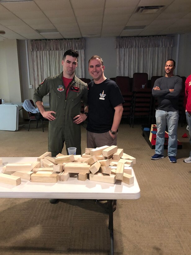 Col. Tom “Sling” Bladen, 104th Fighter Wing vice commander, right, takes a photo with a 104th Fighter Wing F-15 Eagle Pilot, left, after the officers lose the final round of Jenga and as the enlisted take the win during the wing’s Officer vs. Enlisted Olympics, Feb. 1, 2020. The friendly competition brought wing members together to share camaraderie during their February unit training assembly. (U.S. Air National Guard photo by Senior Master Sgt. Julie Avey)