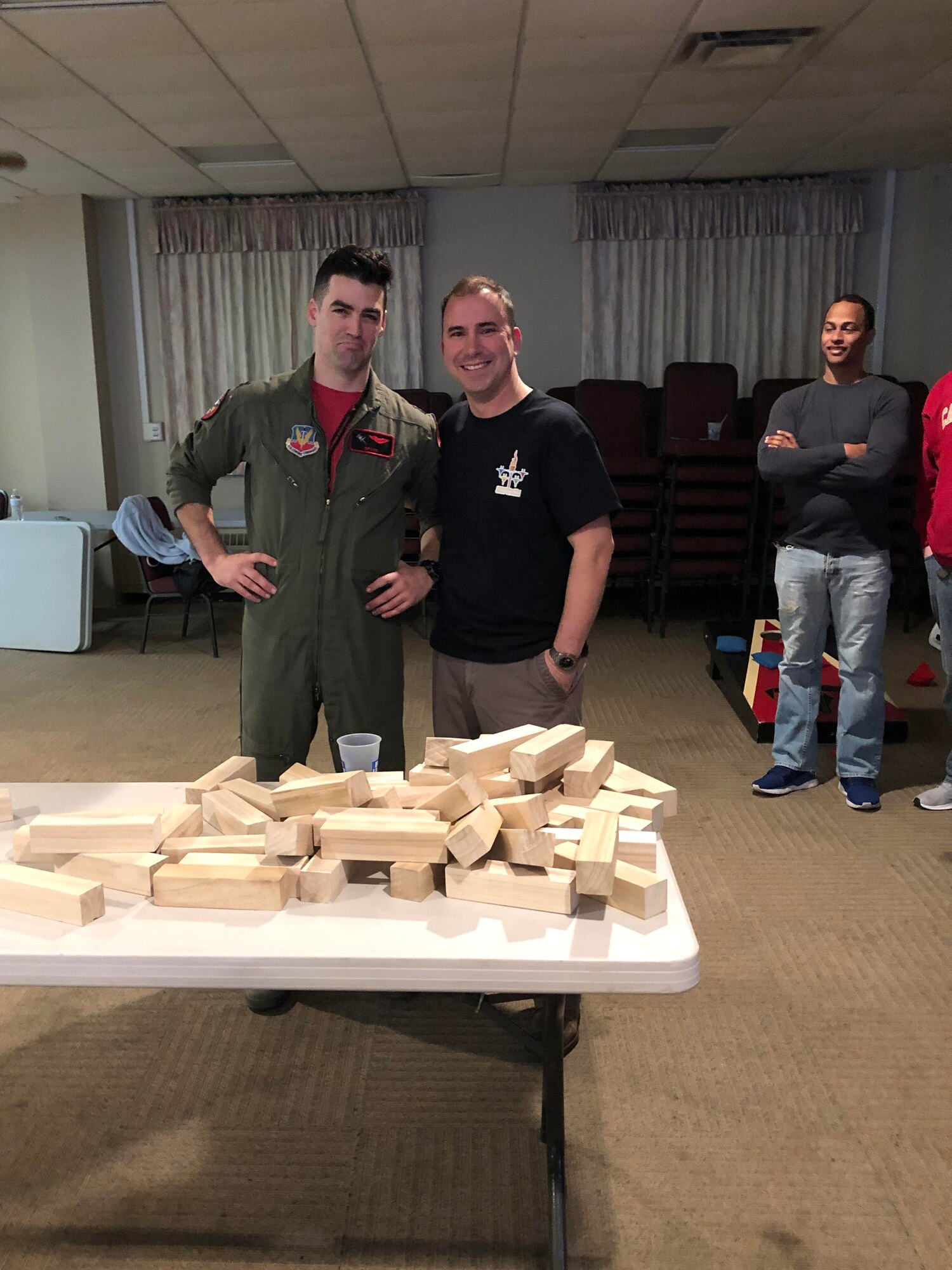 Col. Tom “Sling” Bladen, 104th Fighter Wing vice commander, right, takes a photo with a 104th Fighter Wing F-15 Eagle Pilot, left, after the officers lose the final round of Jenga and as the enlisted take the win during the wing’s Officer vs. Enlisted Olympics, Feb. 1, 2020. The friendly competition brought wing members together to share camaraderie during their February unit training assembly. (U.S. Air National Guard photo by Senior Master Sgt. Julie Avey)