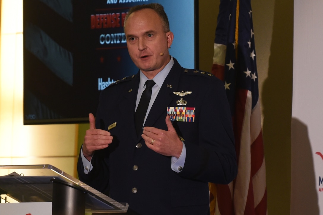 A man in a military uniform speaks from behind a podium.