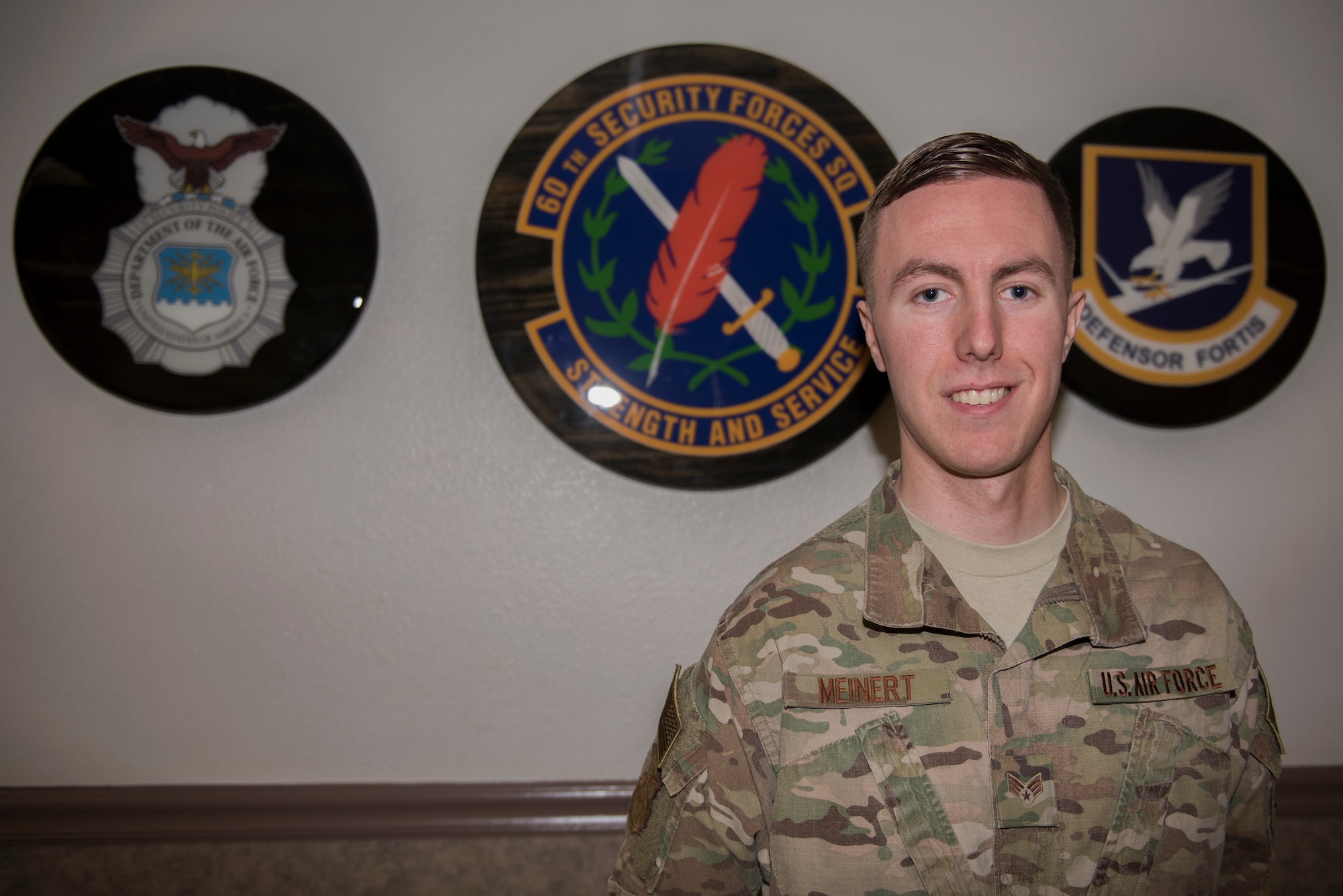 U.S. Air Force Senior Airman Anthony Meinert, 60th Security Forces Squadron installation entry controller, stands in front of the 60th SFS emblem March 3, 2020, at Travis Air Force Base, California. Meinert was the Warrior of the Week from March 1-7. The program recognizes Airmen who have made significant contributions to their units. (U.S. Air Force photo by Airman 1st Class Cameron Otte)