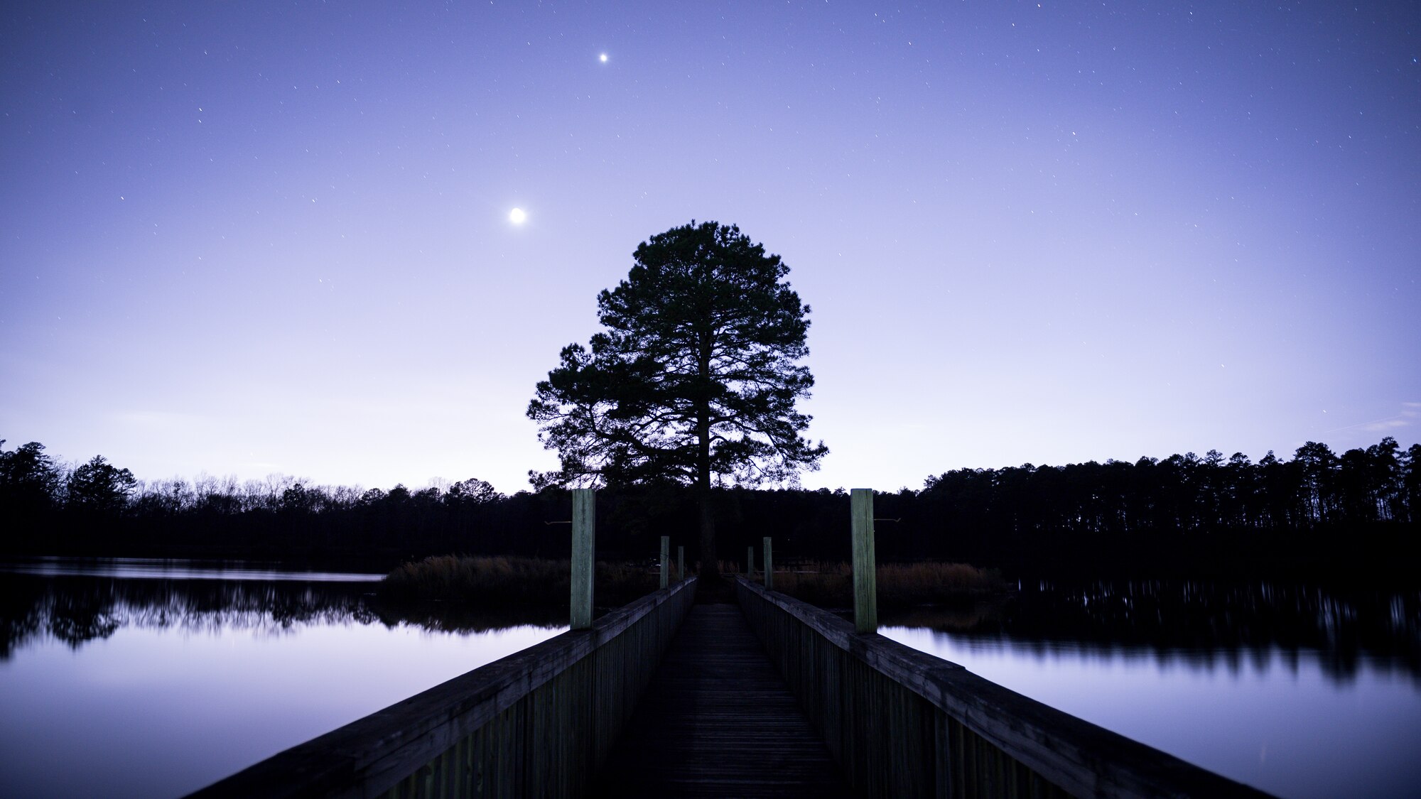 The moon rises over Lake Harmon at Barksdale Air Force Base, La., Feb. 26, 2020. Barksdale occupies over 22,000 acres, offering seven lakes and ten forest ponds.