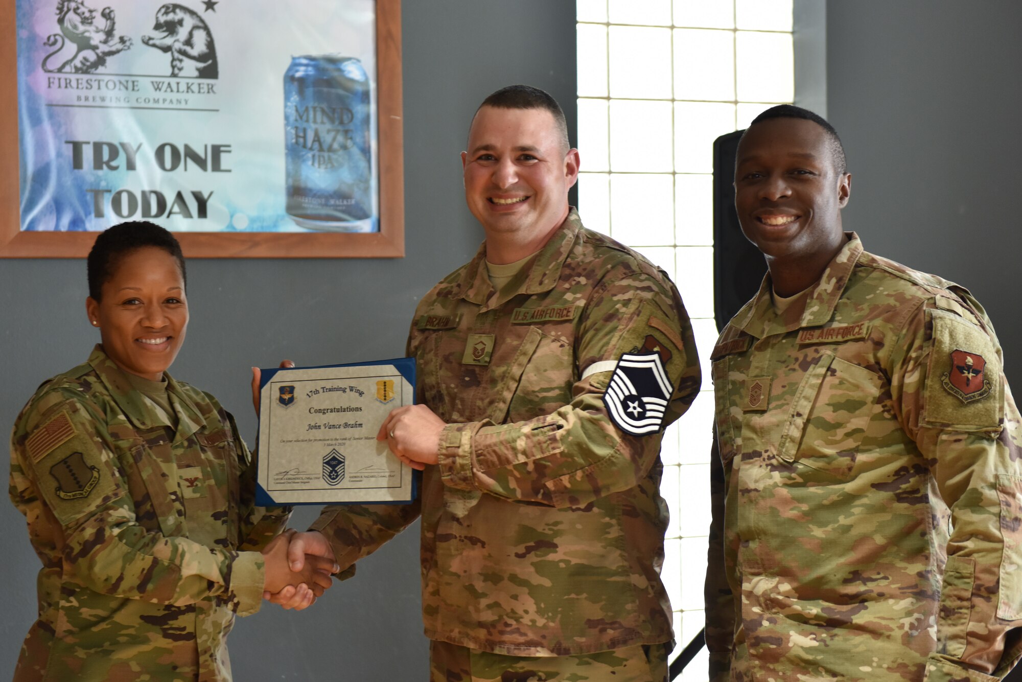 U.S. Air Force Col. Lauren Bryd, 17th Medical Group commander, presents Senior Master Sgt. select John Brahm, 17th Communications Squadron flight chief, with a certificate indicating his line number during the senior master sgt. release party at the event center on Goofellow Air Force Base, Texas, March 3, 2020. A line number indicates when the individual will officially promote to the rank that they have earned. (U.S. Air Force photo by Senior Airman Seraiah Wolf)