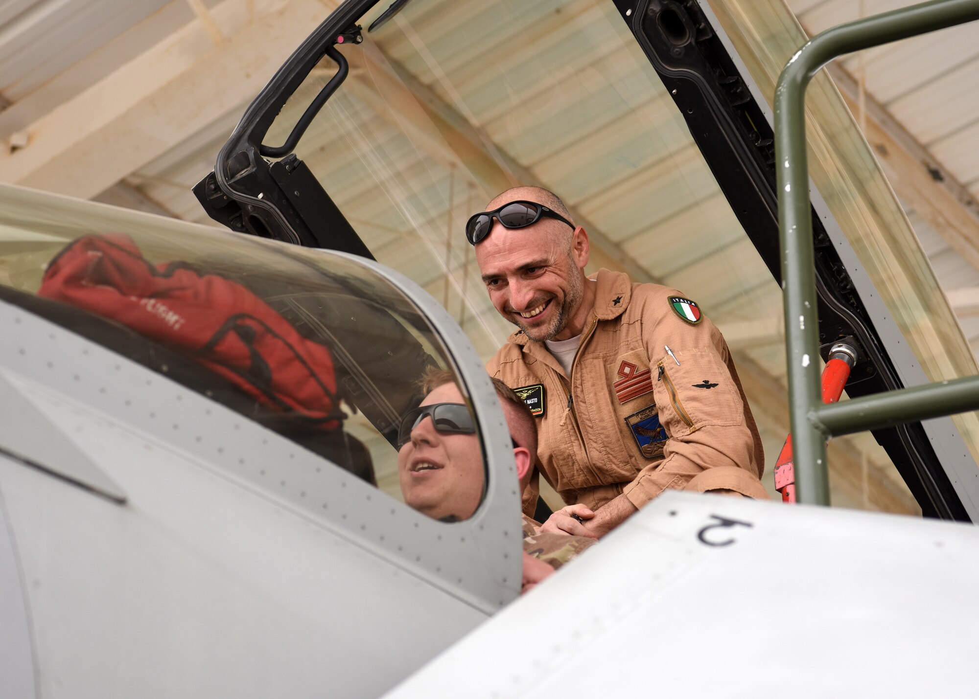 Pilot showcases aircraft to fellow military member.