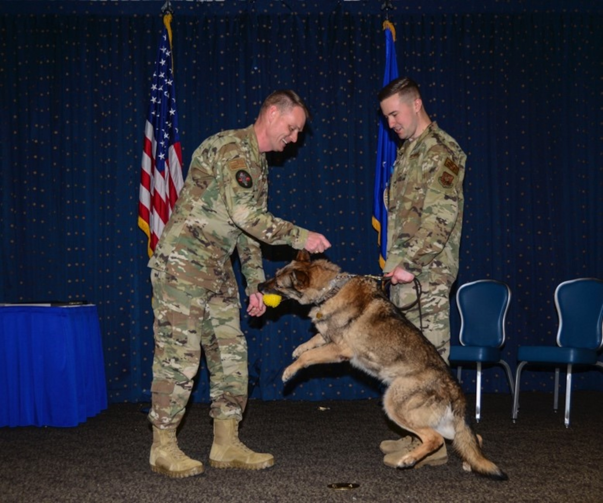Commander gives military working dog a toy upon retirement.