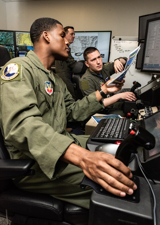 A sensor operator and his pilot look at a strategy on paper.