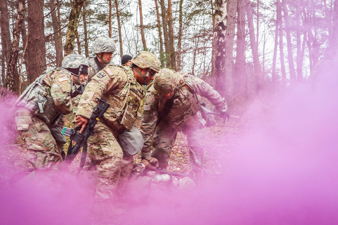 Soldiers train while surrounded by purple smoke.