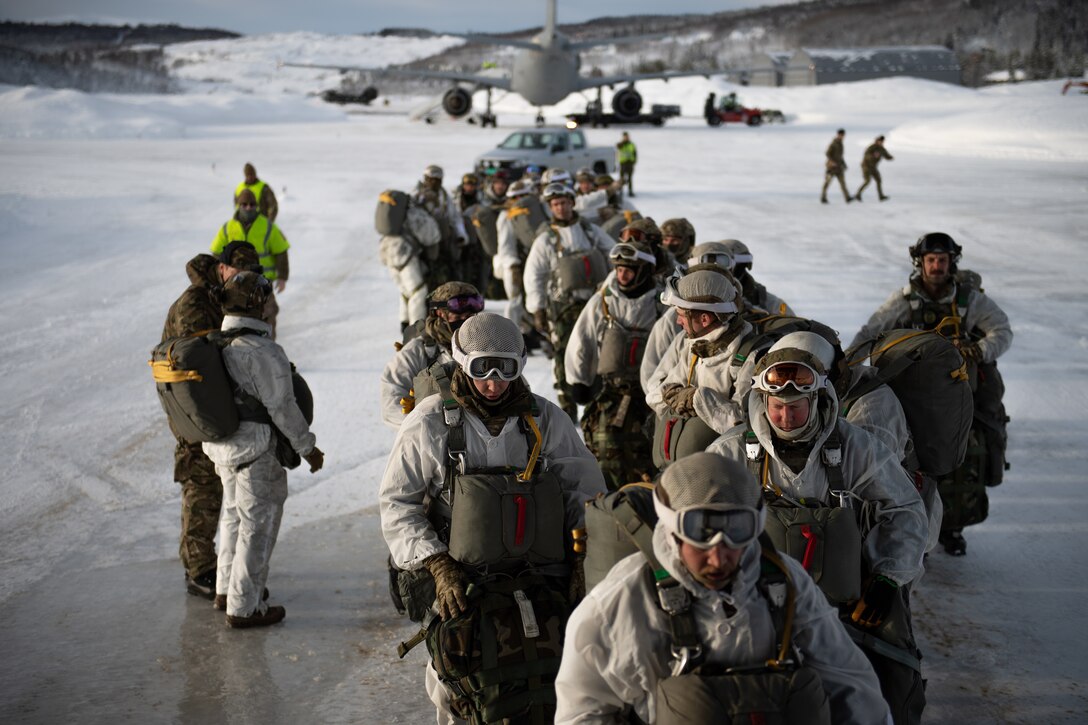 U.S. Air Force Tactical Air Control Party Airmen and British Royal Marines Commandos board a C-130J Super Hercules at an airport in Bardufoss, Norway, prior to Exercise Cold Response 20.