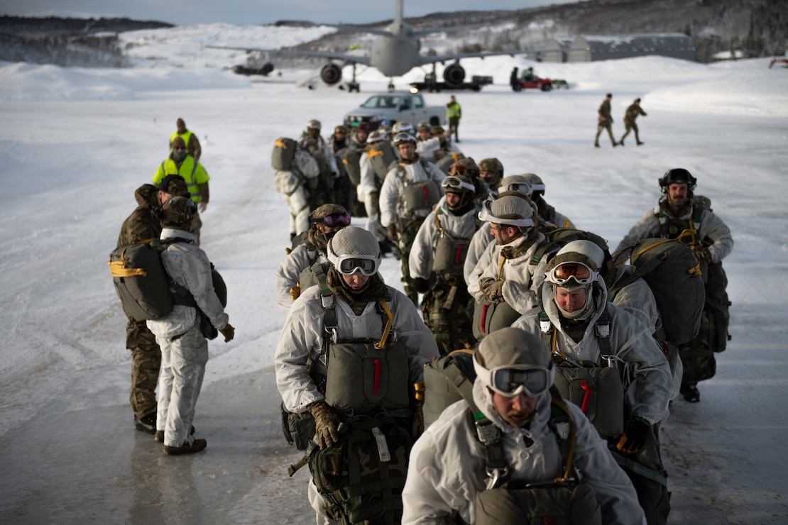 U.S. Air Force Tactical Air Control Party Airmen and British Royal Marines Commandos board a C-130J Super Hercules at an airport in Bardufoss, Norway, prior to Exercise Cold Response 20.