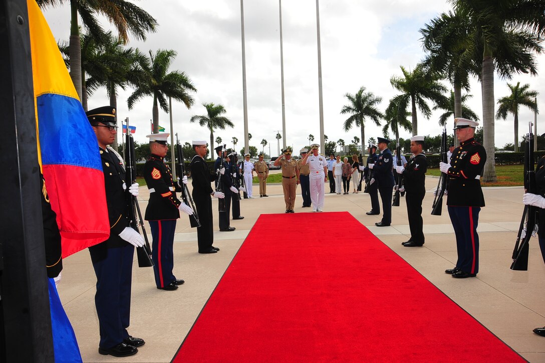 Navy Adm. Craig Faller, the Commander of U.S. Southern Command, and Colombia's Chief of Defense Gen. Luis Navarro Jiménez render salutes at SOUTHCOM headquarters.