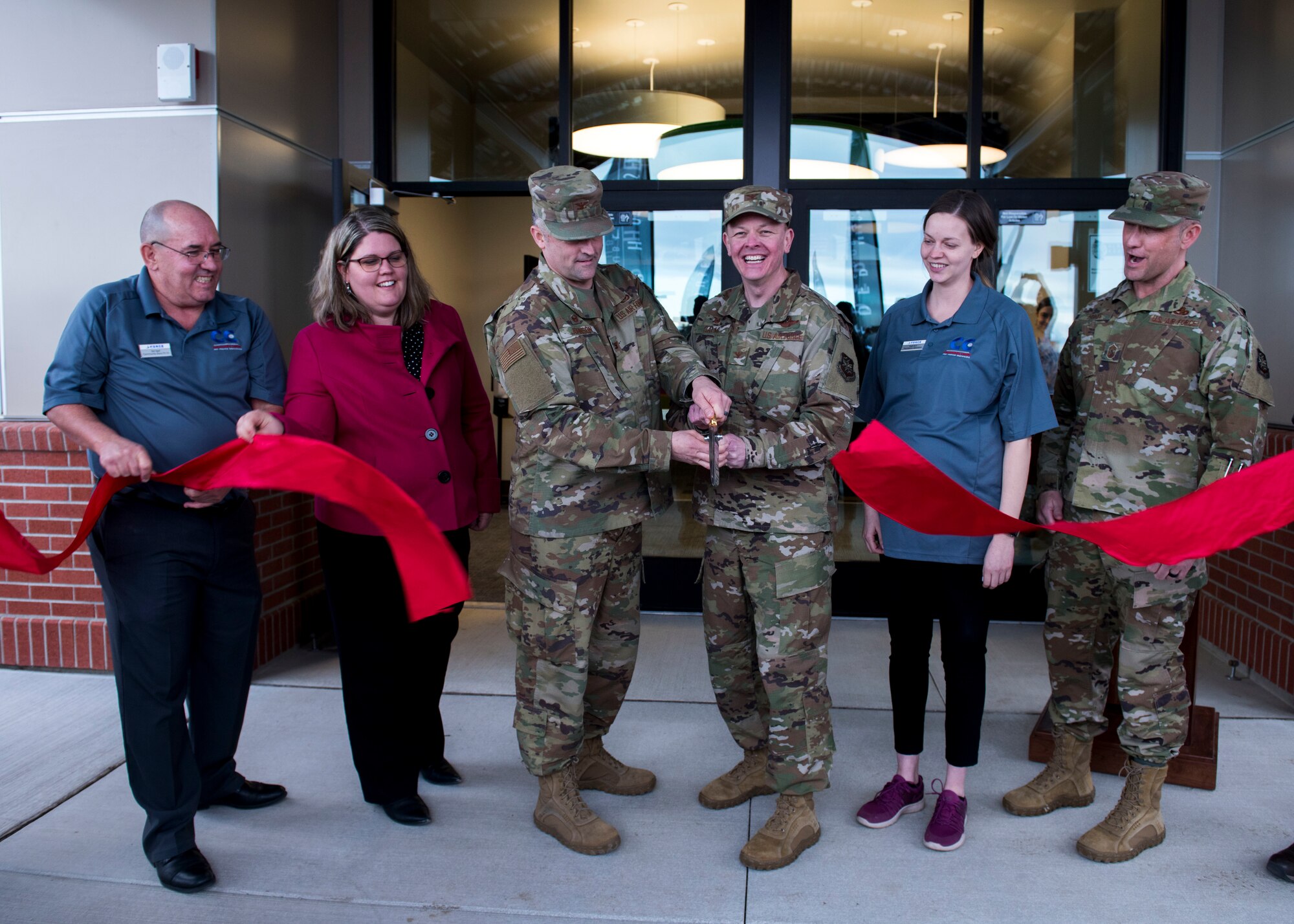U.S. Air Force Col. Michael Johnson, 92nd Mission Support Group commander (center left), and U.S. Air Force Col. Derek Salmi, 92nd Air Refueling Wing commander (center right), cut a ribbon as part of the Alder House community center grand opening at Fairchild Air Force Base, Washington, March 2, 2020. The Alder House is attached to the north side of the Red Morgan Center and houses the largest indoor playground on the west coast, virtual reality video games and indoor sports court. (U.S. Air Force photo by Senior Airman Lawrence Sena)