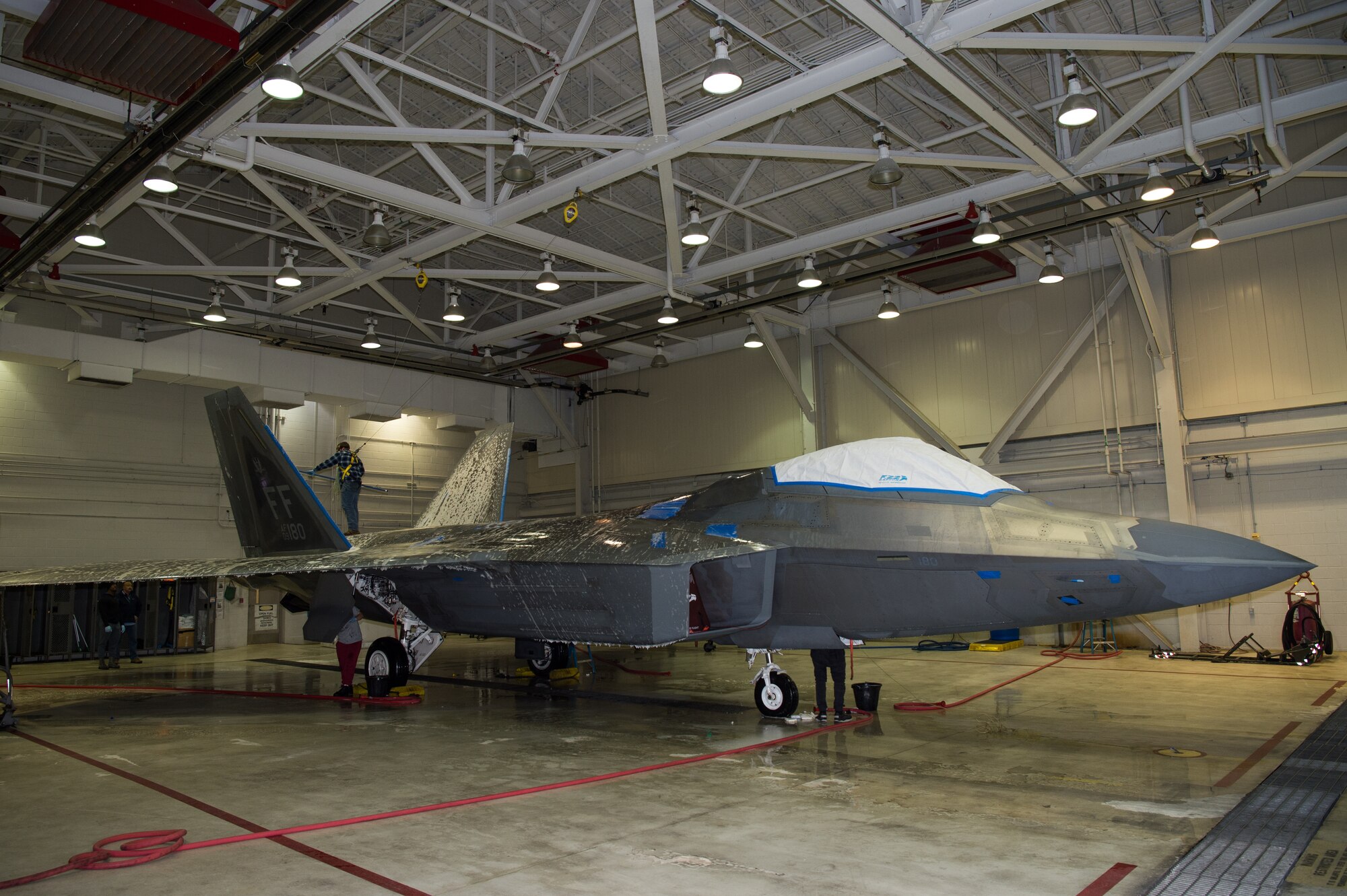 Andrew Sarillana, Shiloh Services Incorporated aircraft wash contractor with the 1st Maintenance Group, washes a U.S. Air Force F-22 Raptor at Joint Base Langley-Eustis, Virginia, Dec 12, 2019.