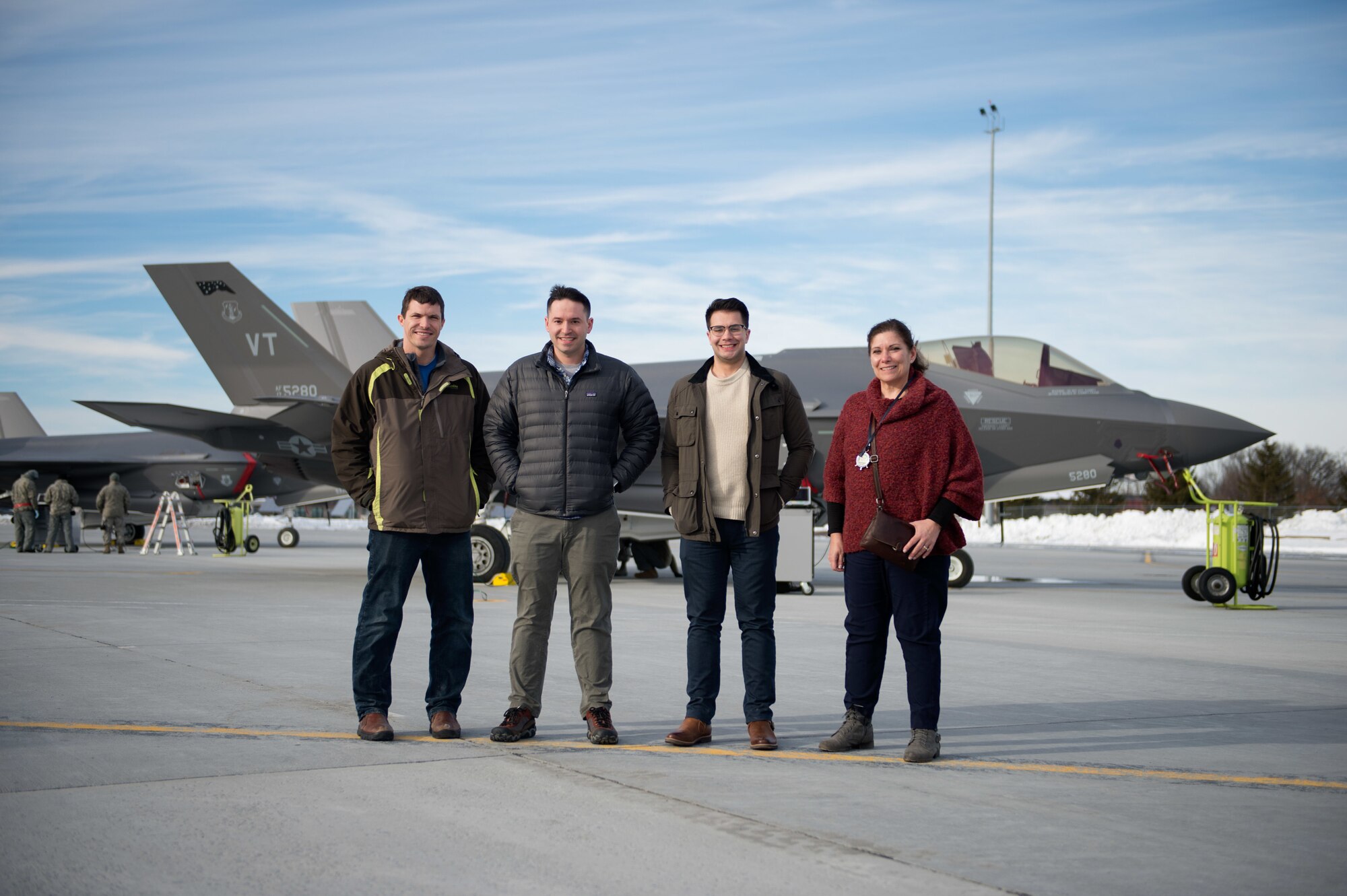 Kessel Run and Air Force civilian employees, Mr. Nathan Edwards, Mr. Alexander Morris, SSgt Andrew McFarland, and Ms. Diane Ponte Saia, gather together in front of an F-35A Lightning II