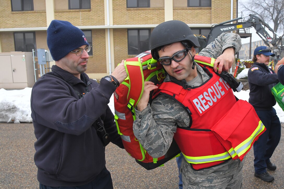 (Left to right) James Weston, Fire and Emergency Services rescue captain, assists Airman 1st Class Gabriel Briones, F&ES firefighter, as he gears up in ballistic protective and medical response gear during a Rescue Task Force exercise Dec. 5, 2019, at Hill Air Force Base, Utah. The RTF is a tactic used during active shooter/hostile events and consists of “task forces” or integrated teams of security forces defenders and fire and emergency medical services responders working together to provide medical care to victims during an incident much faster. (U.S. Air Force photo by Todd Cromar)