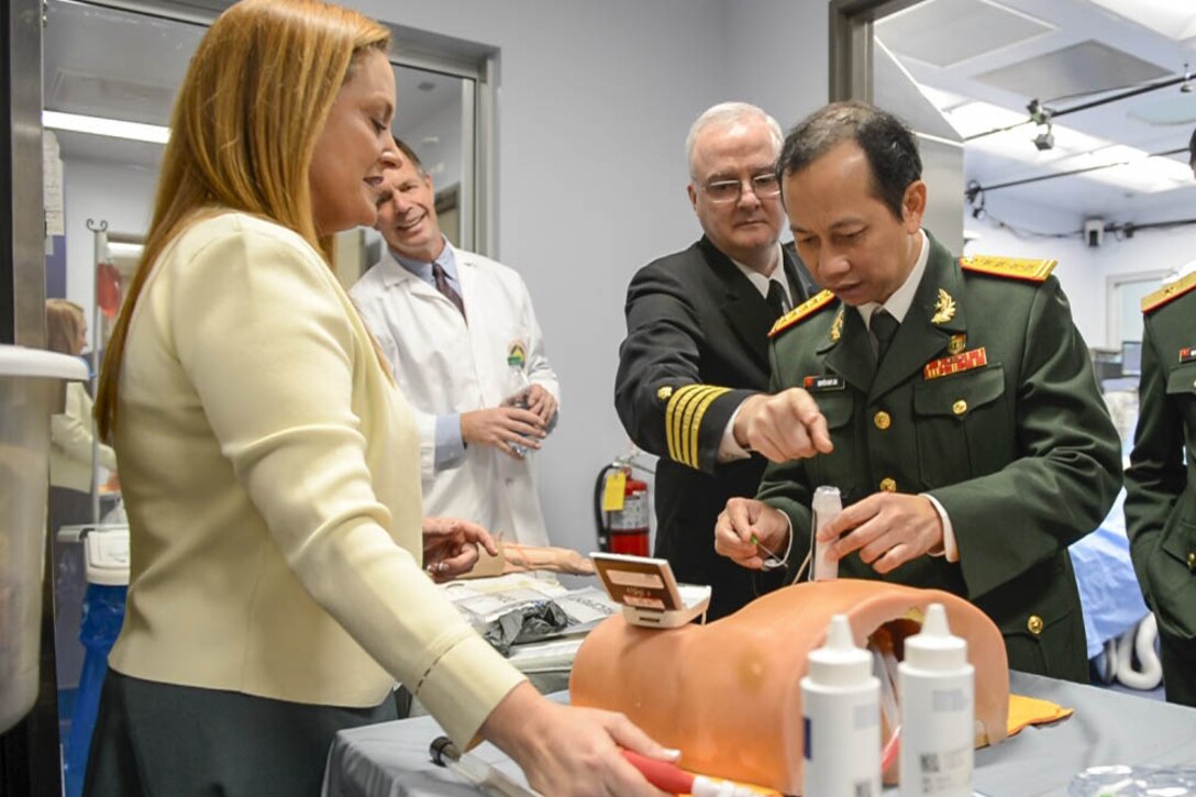 Medical personnel train using a mannequin.