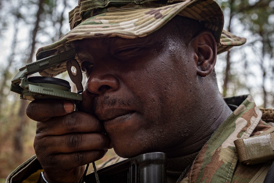 Photo of an Airman shooting an azimuth during land navigation training.