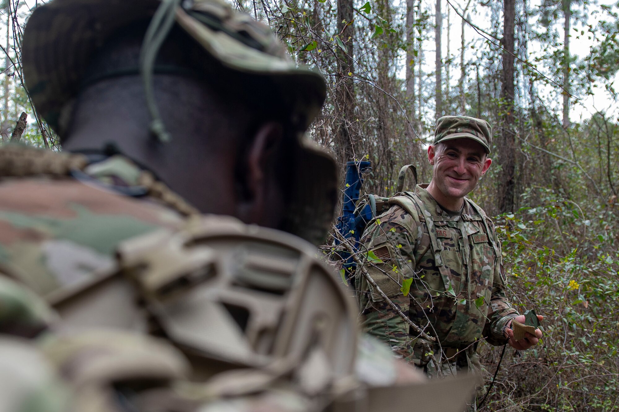 Photo of Airman sharing a laugh during land navigation training.