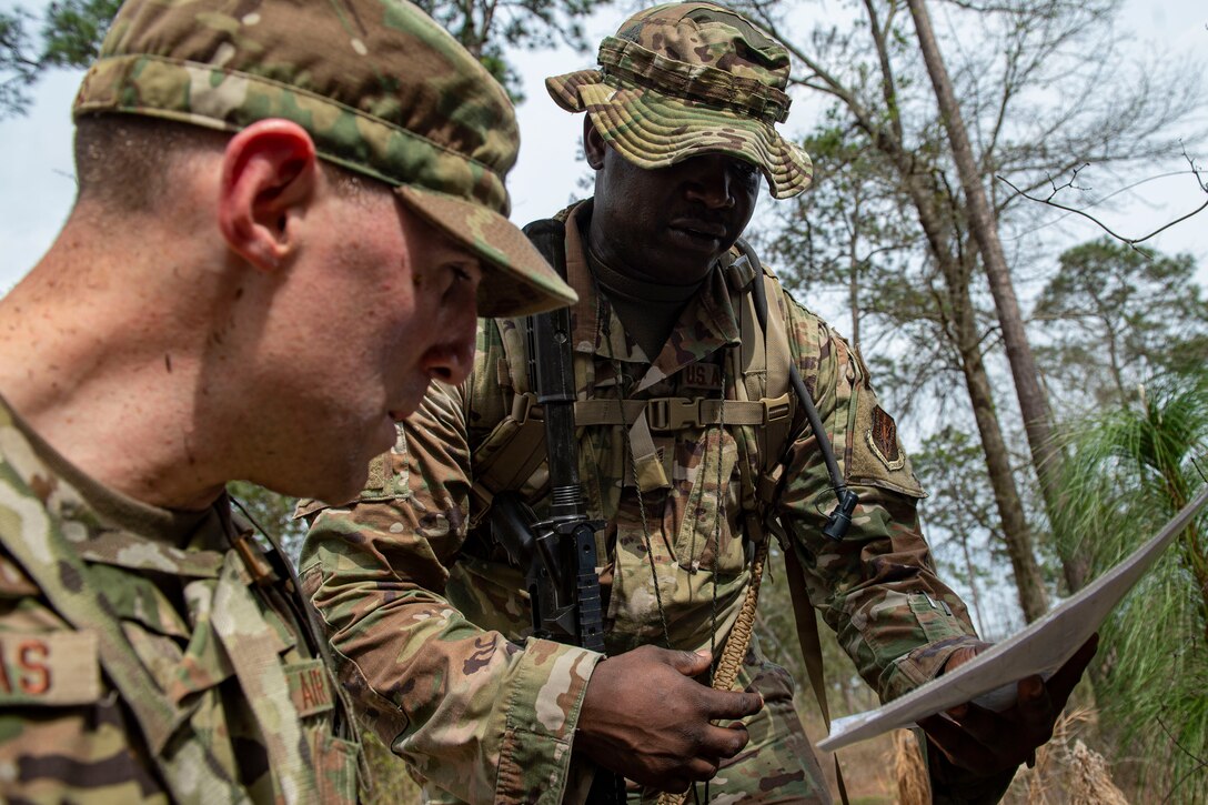 Photo of Airmen discussing strategy during land navigation training.