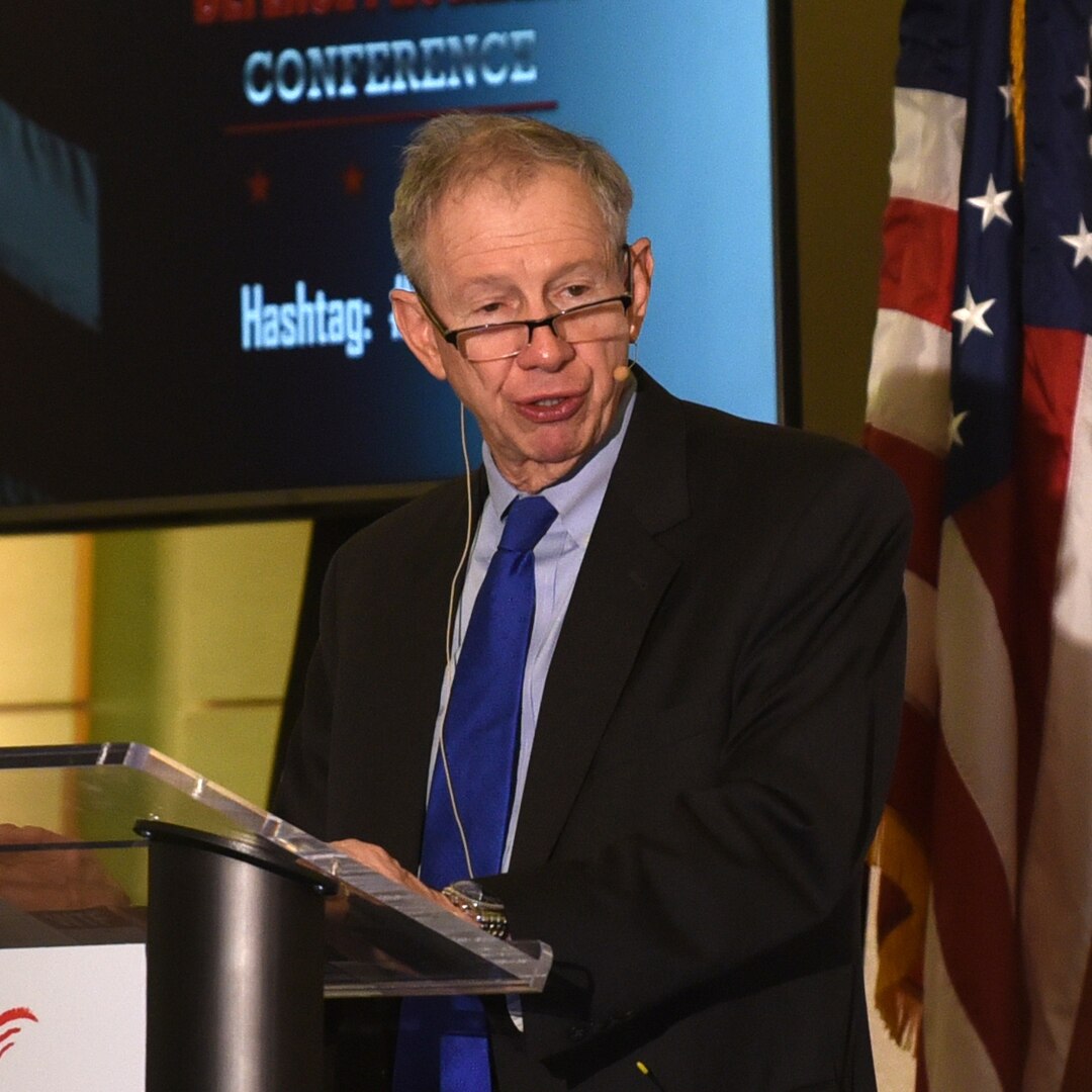 A man stands at a lecturn to speak.