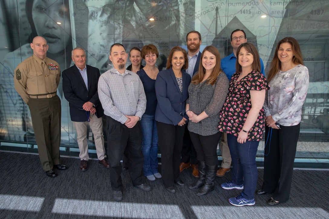 U.S. Marine Sgt. Maj. Troy E. Black, the 19th sergeant major of the Marine Corps poses for a photo with professionals from the Center of Naval Analysis and Solutions (CNA) in Arlington, V.A., March 4, 2020. Sgt. Maj. Black visited the CNA staff to thank them for their assistance in developing analytics aimed at improving Talent Development, Health, Wellness, and Fitness, and Personal Professional Education opportunities for Marines and Sailors.  (U.S Marine Corps photo by Sgt. Victoria Ross)