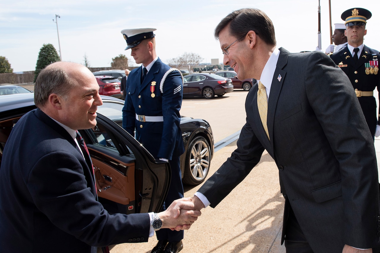 Two men shake hands.