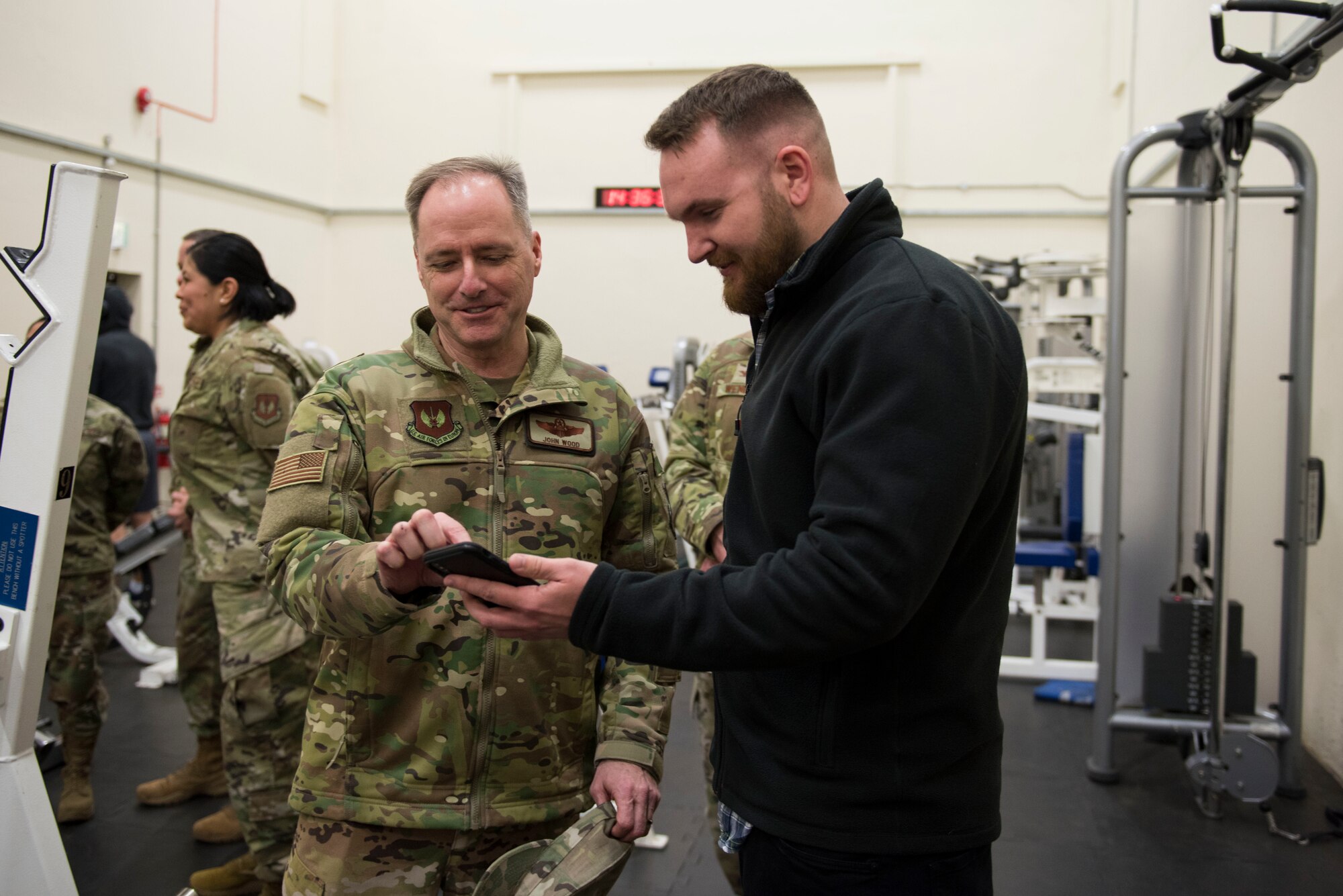 Daniel Prentice, 423rd Civil Engineer Squadron chief of requirements and optimization, shows photos of his car project to Maj. Gen. John Wood, Third Air Force commander, during a tour of the fitness center at RAF Molesworth, England, March 3, 2020. Wood and Chief Master Sgt. Randy Kwiatkowski, Third Air Force command chief, visited 501st Combat Support Wing Airmen and facilities and recognized outstanding performers in the wing. (U.S. Air Force photo by Airman 1st Class Jennifer Zima)