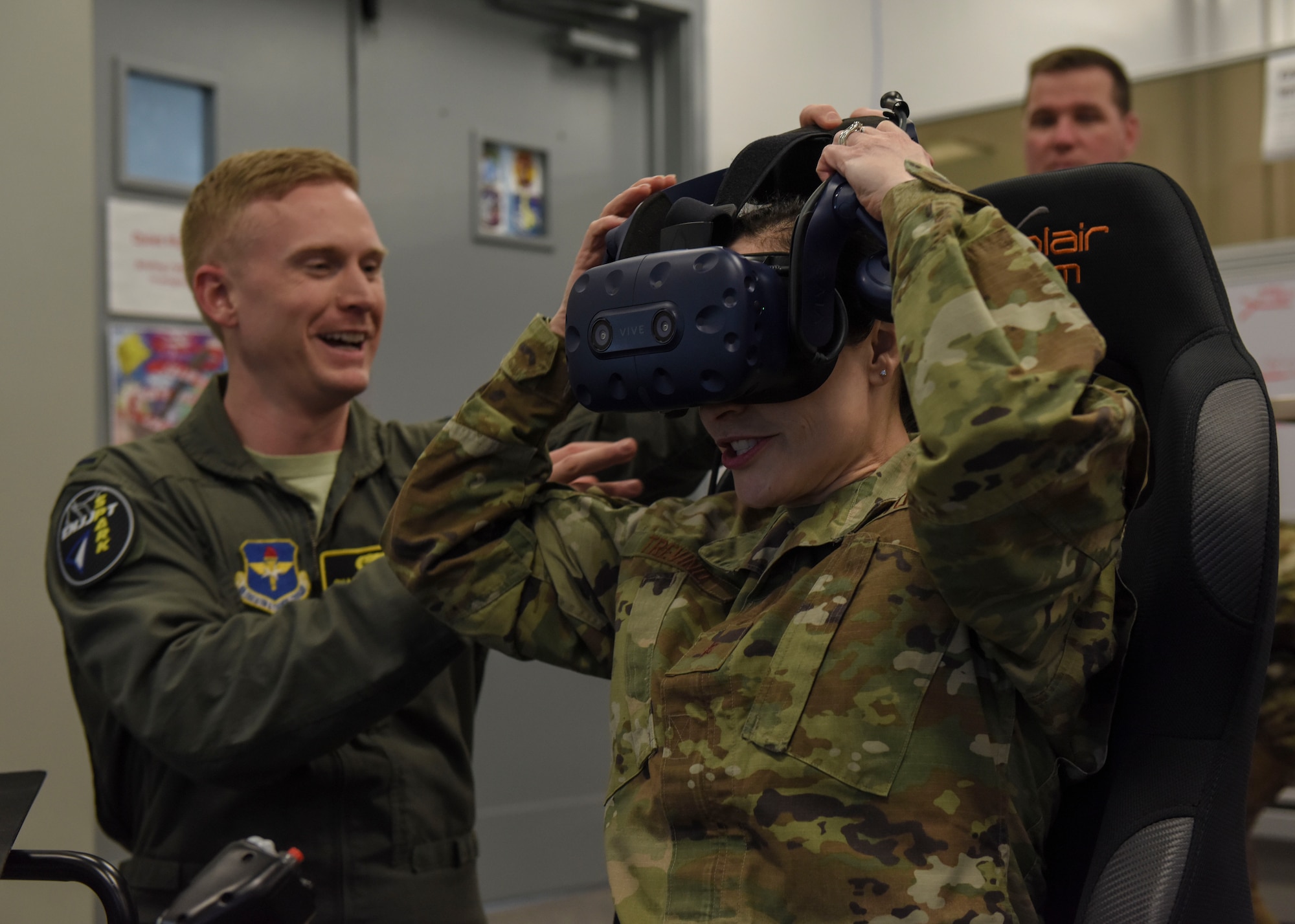 Lt. Charles Boynton, 80th Flying Training Wing Spark Cell project manager, assists Brig. Gen. Alice Trevino, Air Force Installation Contracting Center commander, with putting on virtual reality goggles at Sheppard Air Force Base, Texas, March 4, 2020. Student pilots use the virtual reality system to prepare themsleves for flight training missions as well as familiarization with flight controls. (U.S. Air Force photo by Senior Airman Ilyana A. Escalona