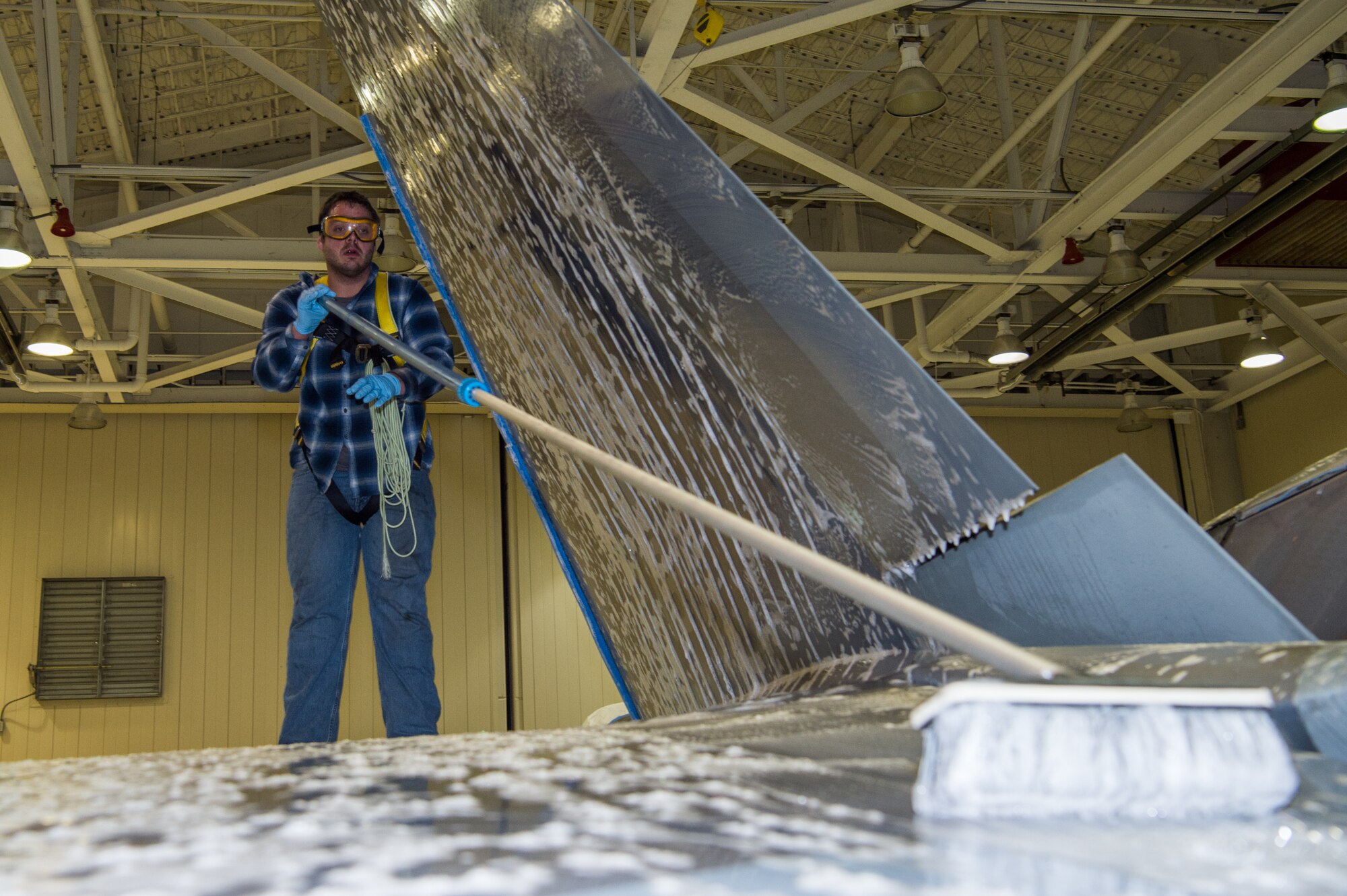 Andrew Sarillana, Shiloh Services Incorporated aircraft wash contractor with the 1st Maintenance Group, washes a U.S. Air Force F-22 Raptor at Joint Base Langley-Eustis, Virginia, Dec 12, 2019.