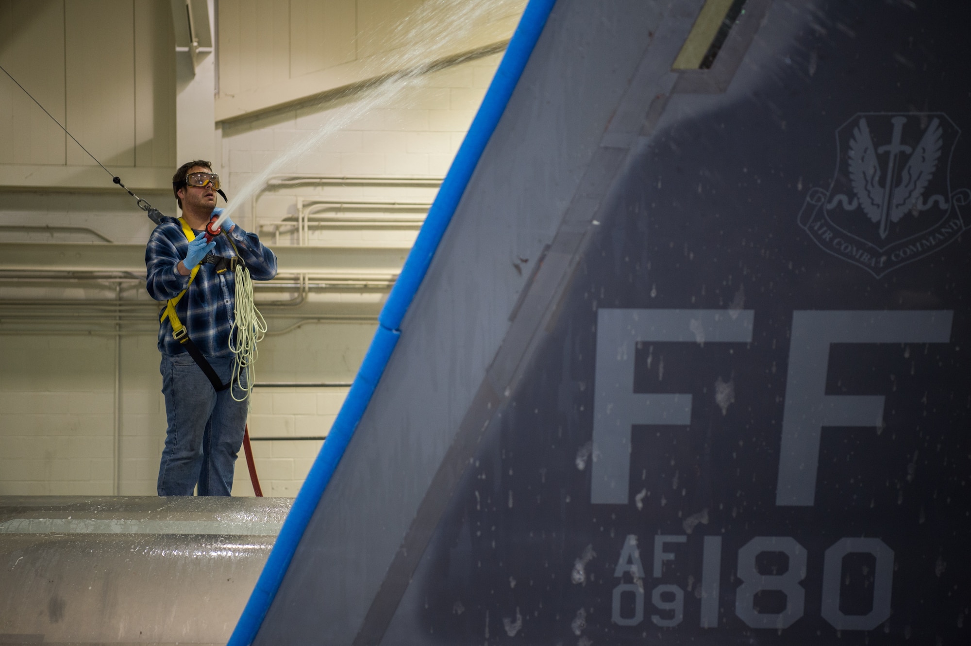 Andrew Sarillana, Shiloh Services Incorporated aircraft wash contractor with the 1st Maintenance Group, washes a U.S. Air Force F-22 Raptor at Joint Base Langley-Eustis, Virginia, Dec 12, 2019.