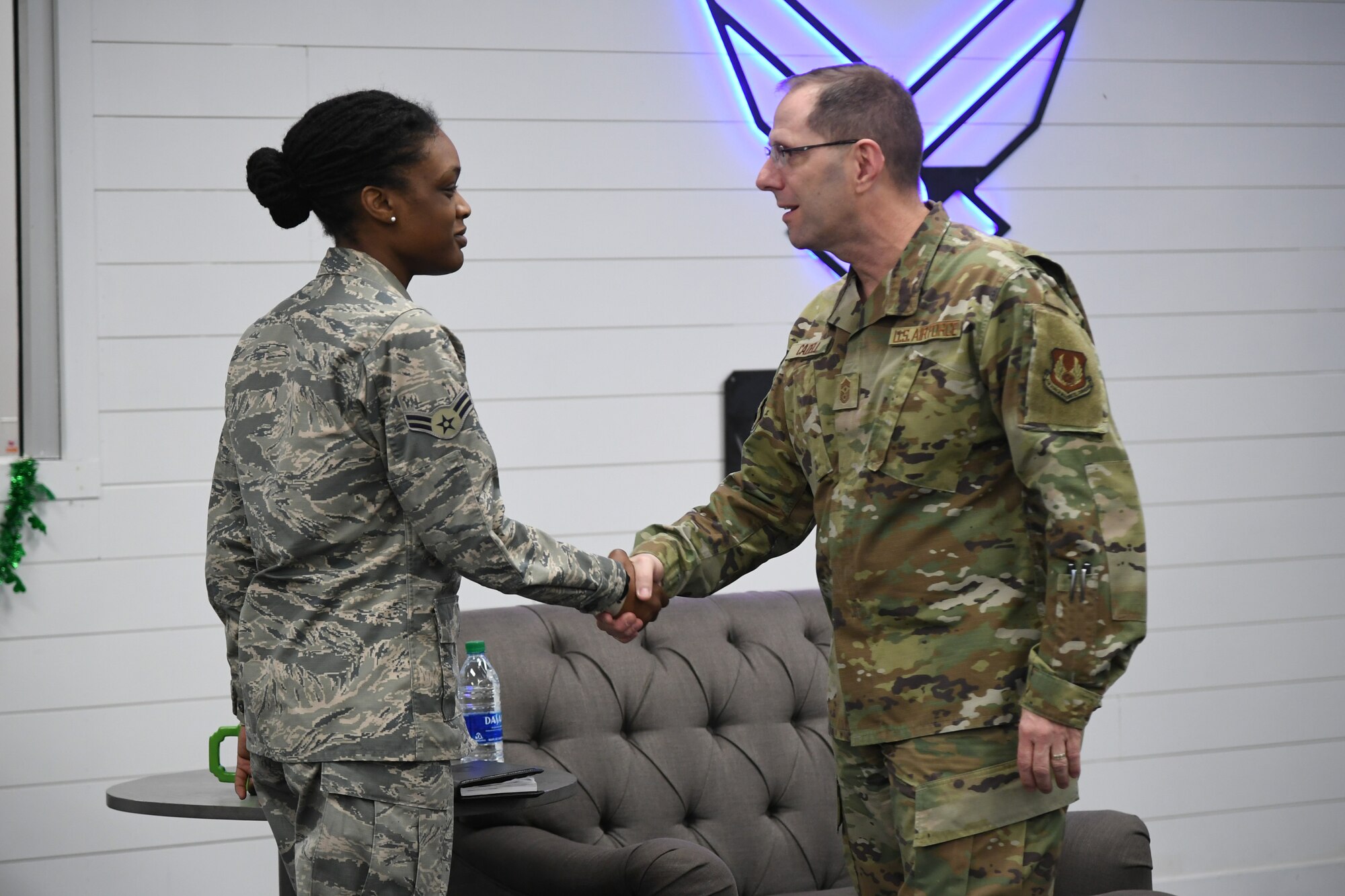Chief Master Sgt. Stanley C. Cadell, Air Force Materiel Command command chief, presents a coin to Airman 1st Class Lelauni Sanders, Air Force Sustainment Center Contracting Directorate, during an early morning “coffee talk” at Hill Air Force Base, Utah, March 3, 2020. Cadell visited Hill AFB March 1-3 to tour facilities and meet with the base’s Airmen. (U.S. Air Force photo by Cynthia Griggs)