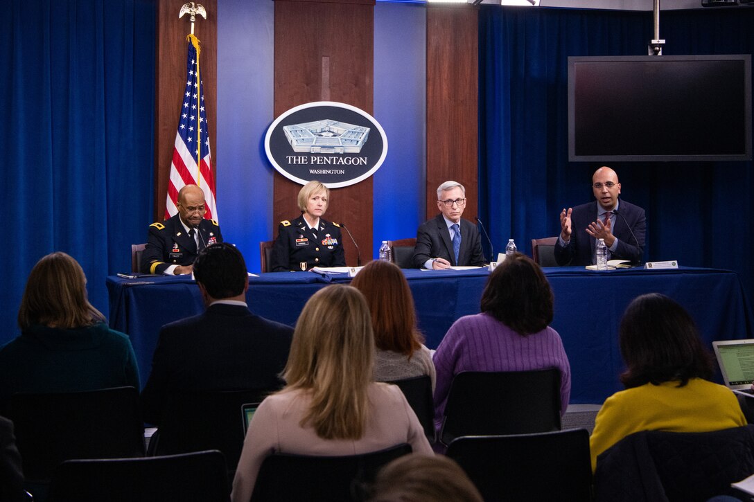 Defense officials sit behind a long table and speak to reporters.