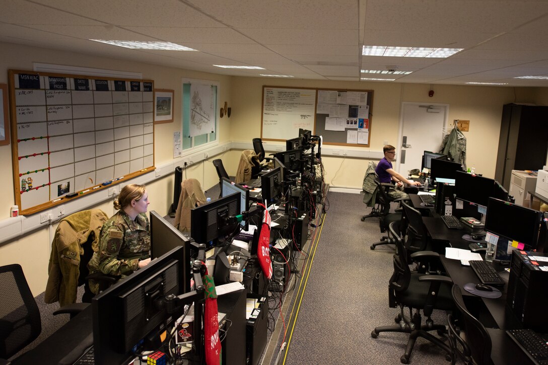 Staff Sgt. Nicole Nagy, 100th Logistics Readiness Squadron wing air expeditionary force reporting tool manager, and Airman 1st Class Ethan Morrow, 100th LRS logistics apprentice, work inside the installation deployment readiness cell March 6, 2020, at RAF Mildenhall, England. The IDRC oversees the deployment process for all units on base, as well as certain geographically separated units. (U.S. Air Force photo by Airman 1st Class Joseph Barron)
