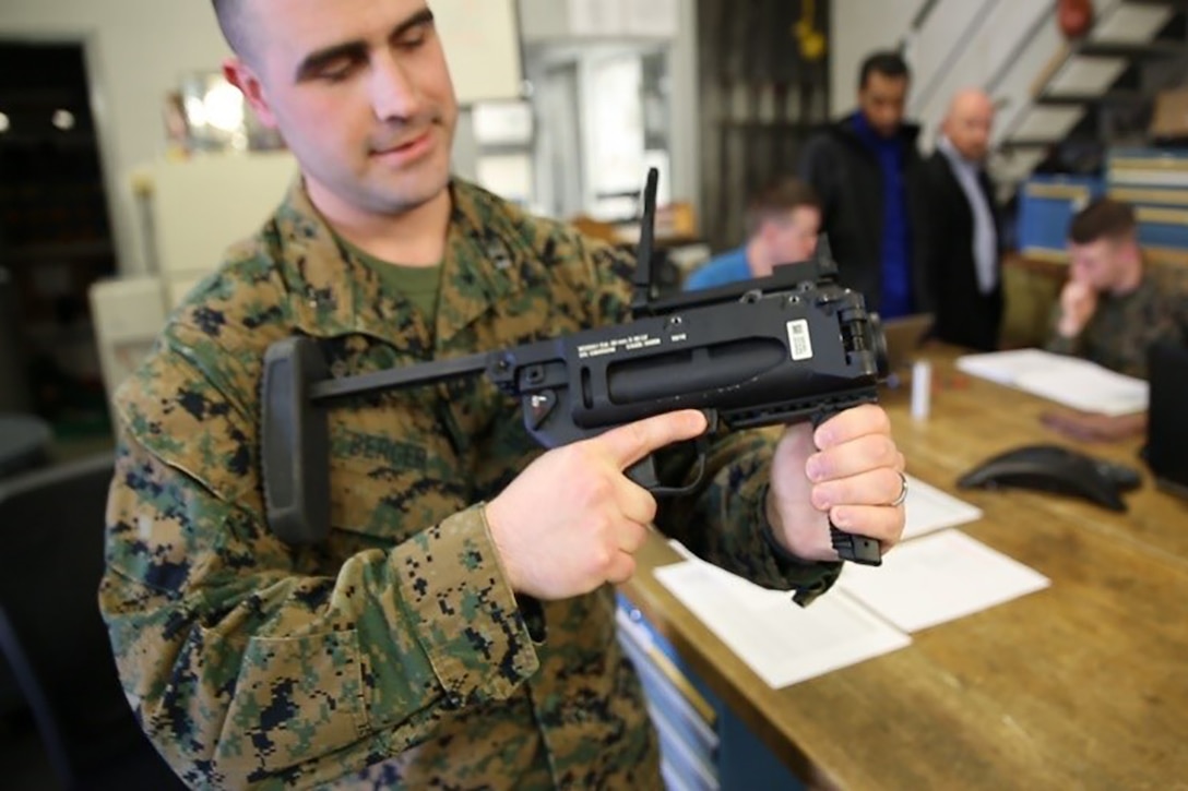 Capt. Nick Berger, project officer in Infantry Weapons at Marine Corps Systems Command, holds the M320A1 during a weeklong review of the system.