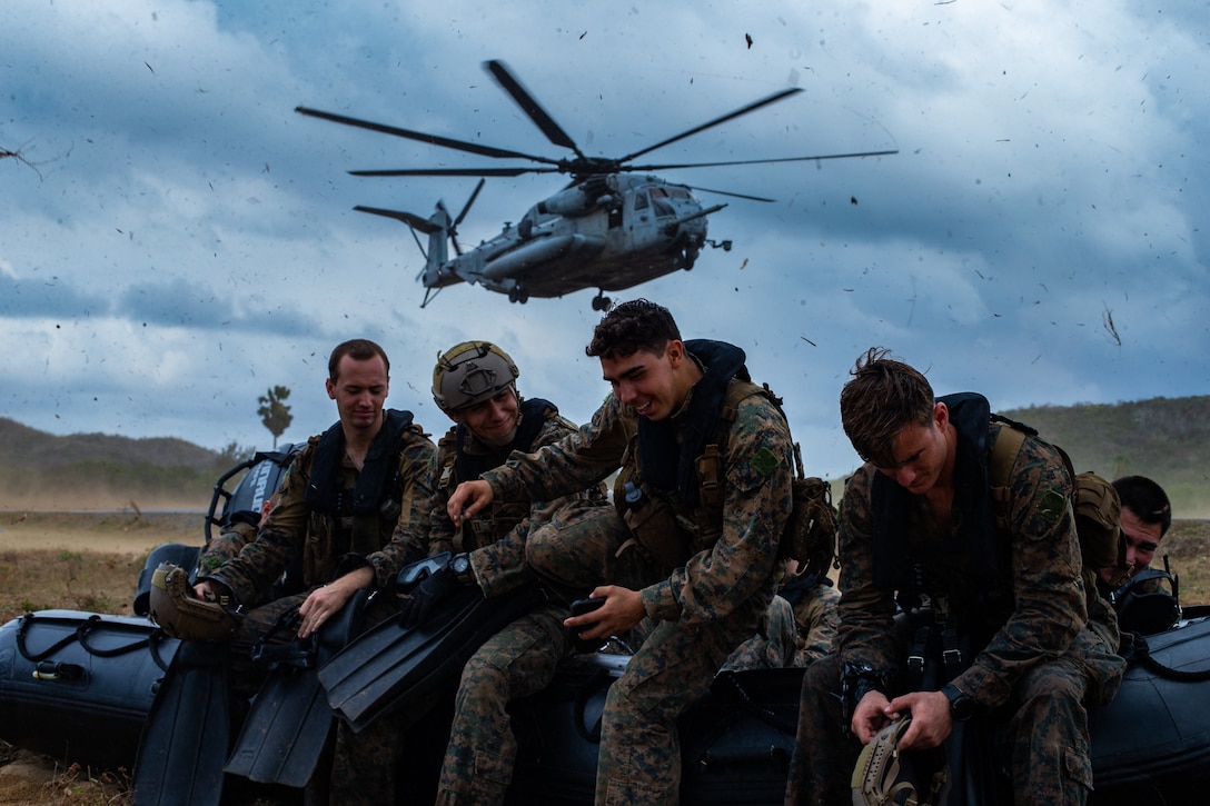 U.S. Marines hold down a combat rubber raiding craft as a CH-53 Super Stallion helicopter comes in to land prior to helocast training in Hat Yao, Kingdom of Thailand, March 5.